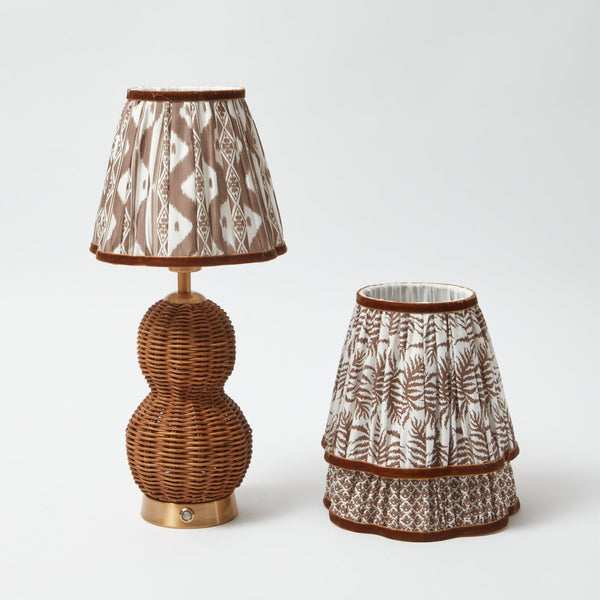 Illuminate your space with the Rattan Bardot Rechargeable Lamp, featuring a captivating design and a warm chocolate lampshade that adds a touch of cozy elegance to your decor.
