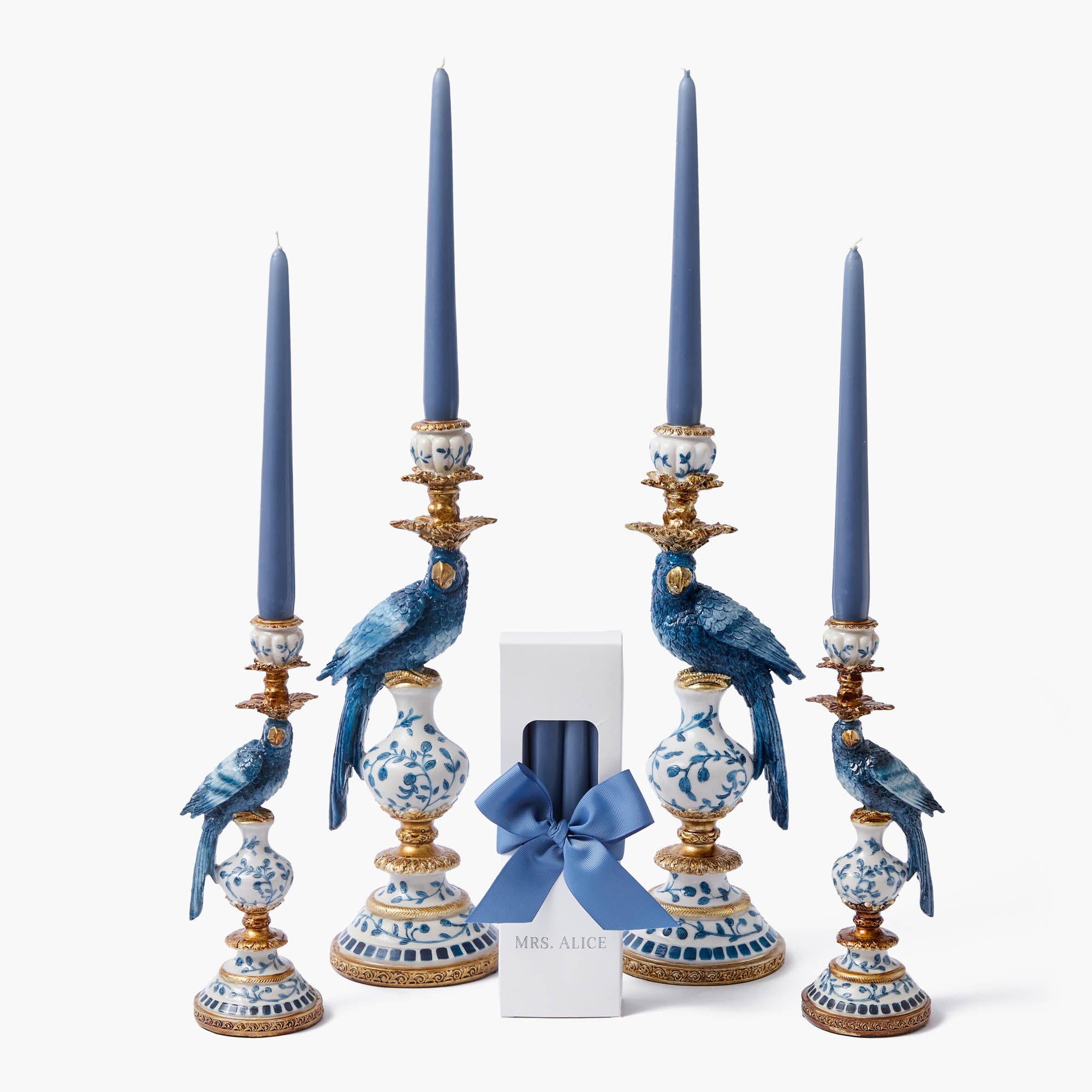A set of ornate blue and white parrot candle holders, accompanied by blue candles.