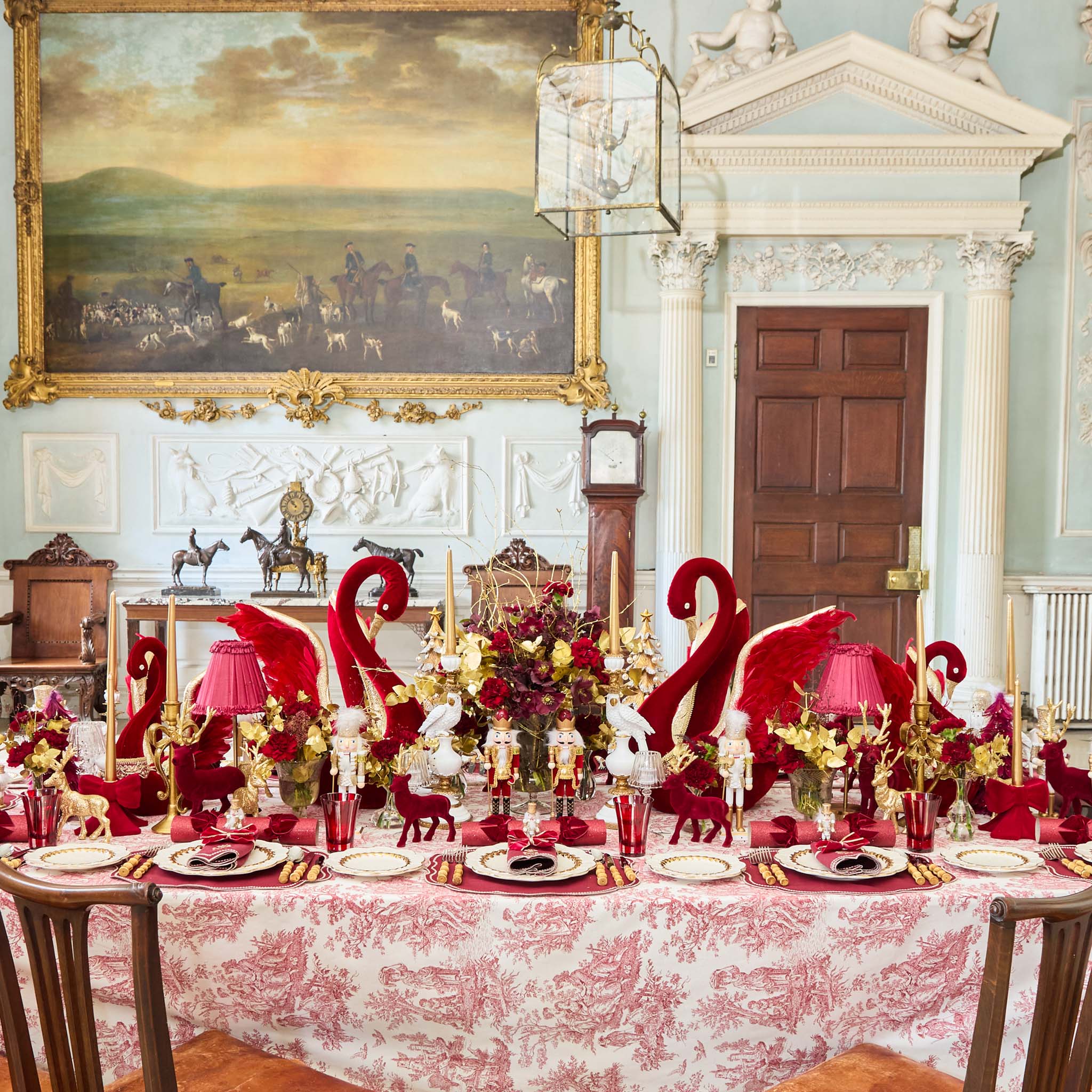 Decorative table setting with red and gold elements in a formal room.
