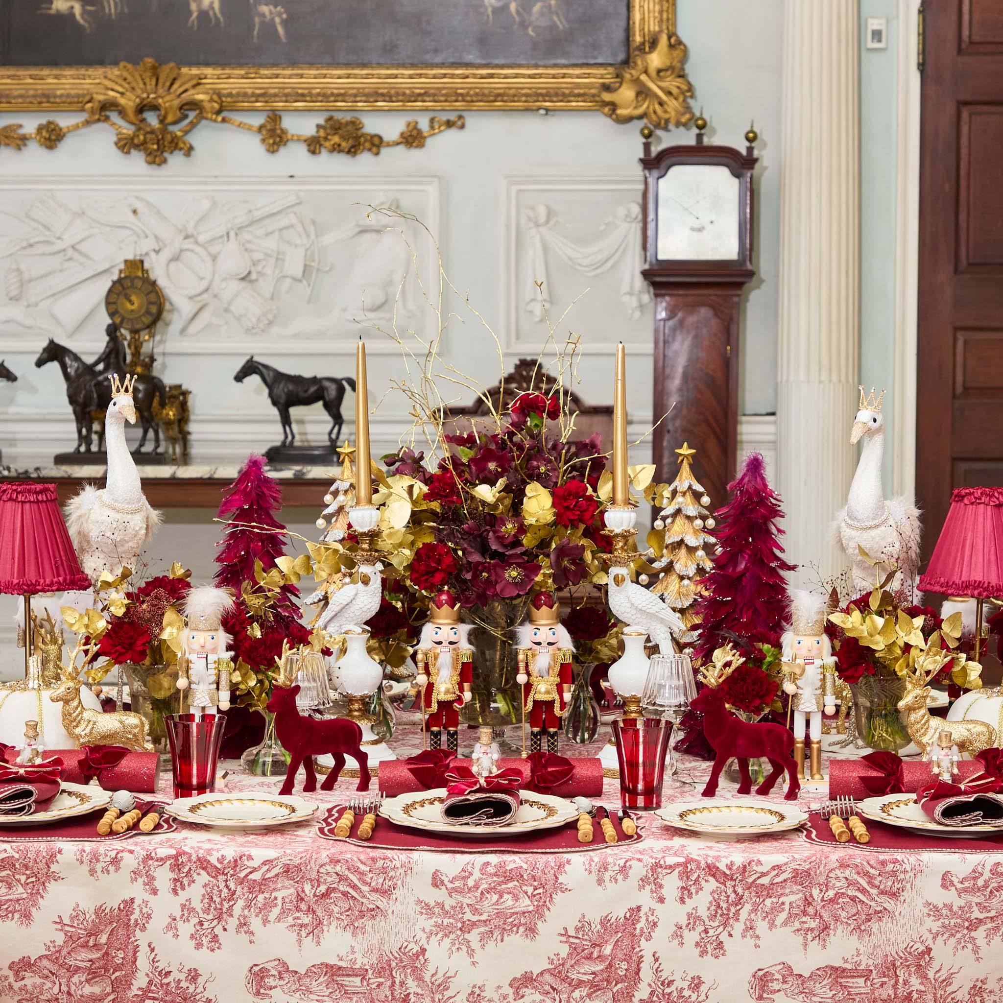 Decorative Christmas table setting with red and gold elements in a formal room.