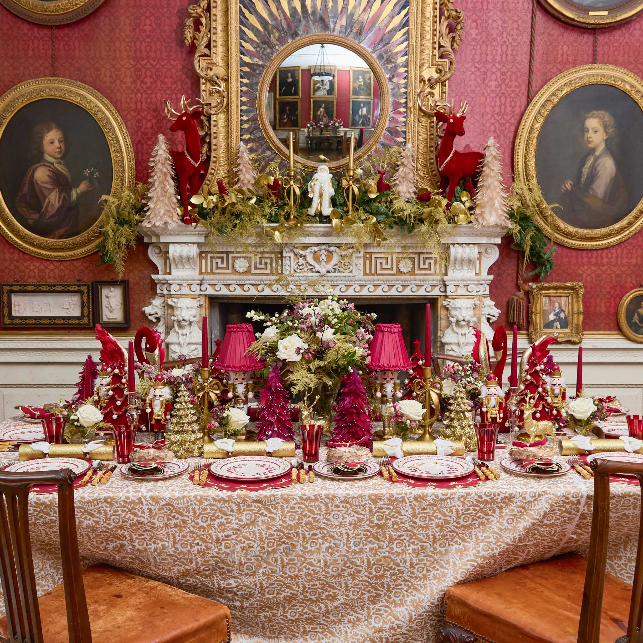 Decorative table setting in a grand room with red walls, gold accents, and classical furniture.