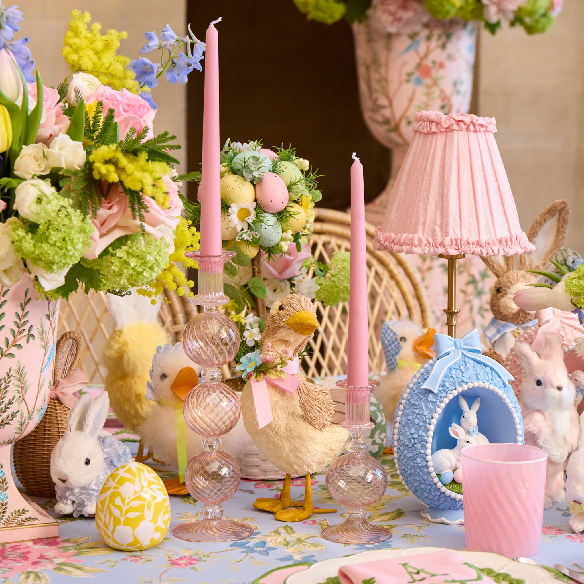 Easter-themed table setting with pastel decorations, candles, and floral arrangements.