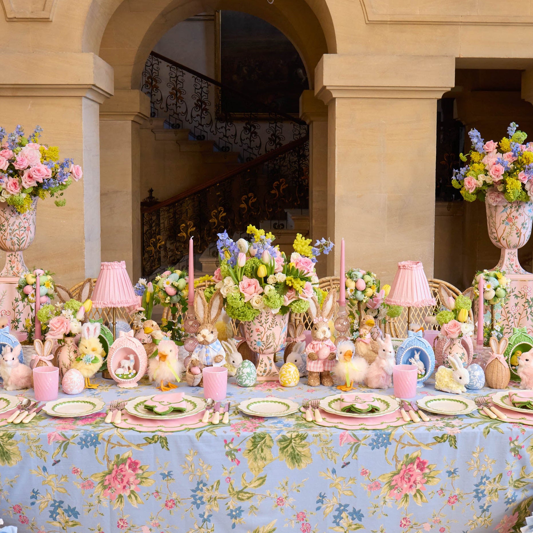 Decorative table setting with floral arrangements, pastel colors, and a floral tablecloth.