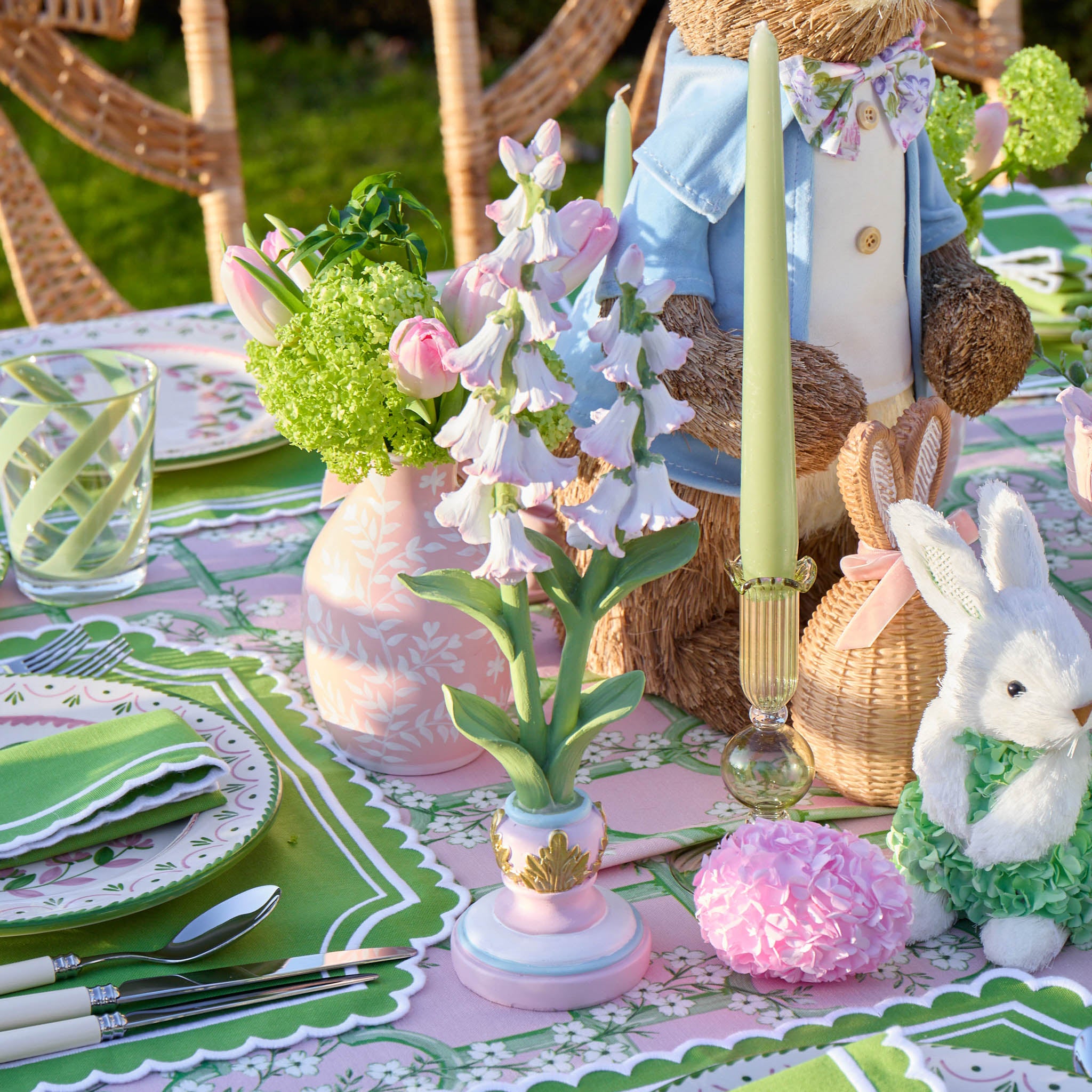 Easter-themed table setting with bunny decorations, flowers, and a teddy bear.