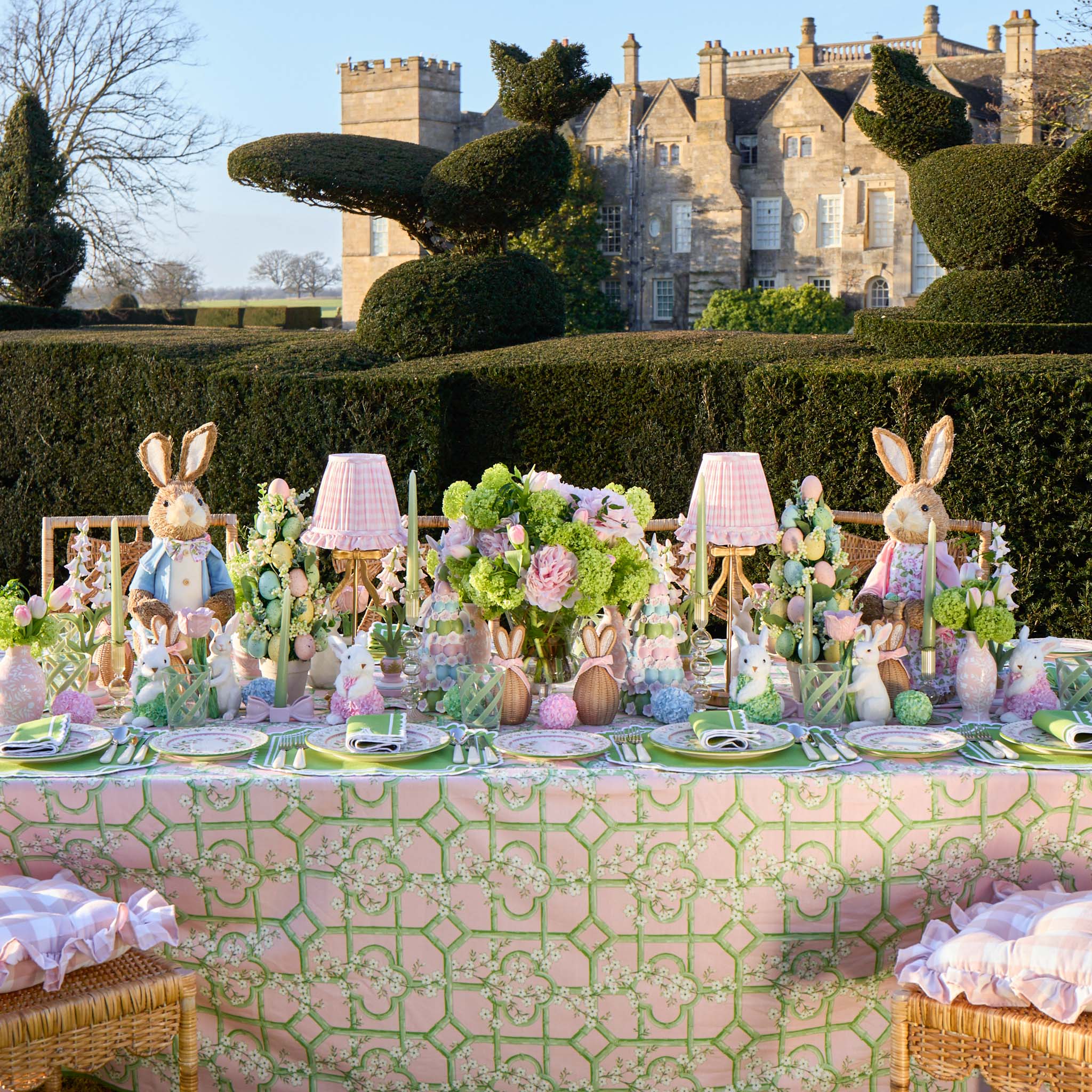 Easter-themed table setting with decorative elements in a garden setting with a castle in the background.