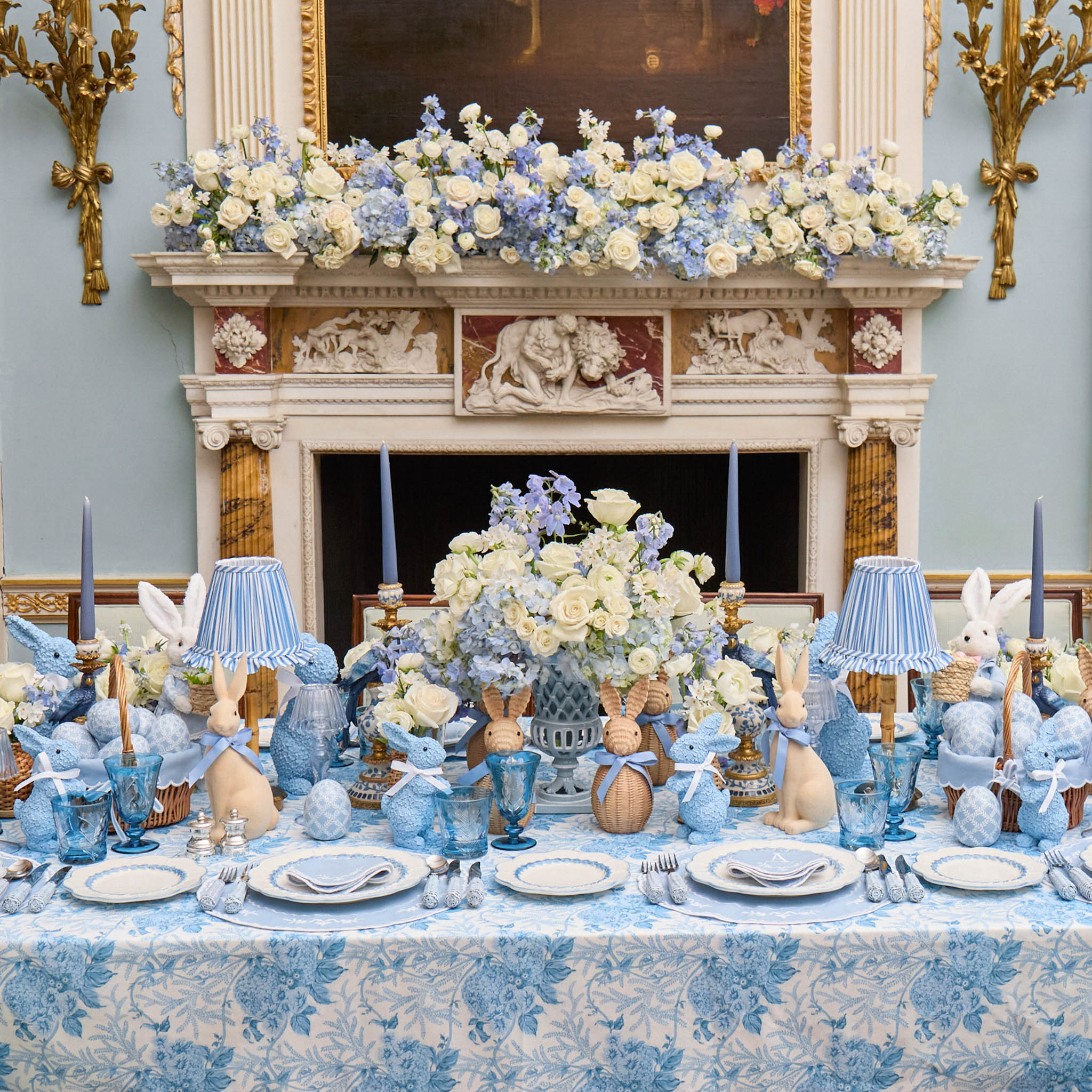 Decorative table setting with blue and white floral arrangements in a formal room.