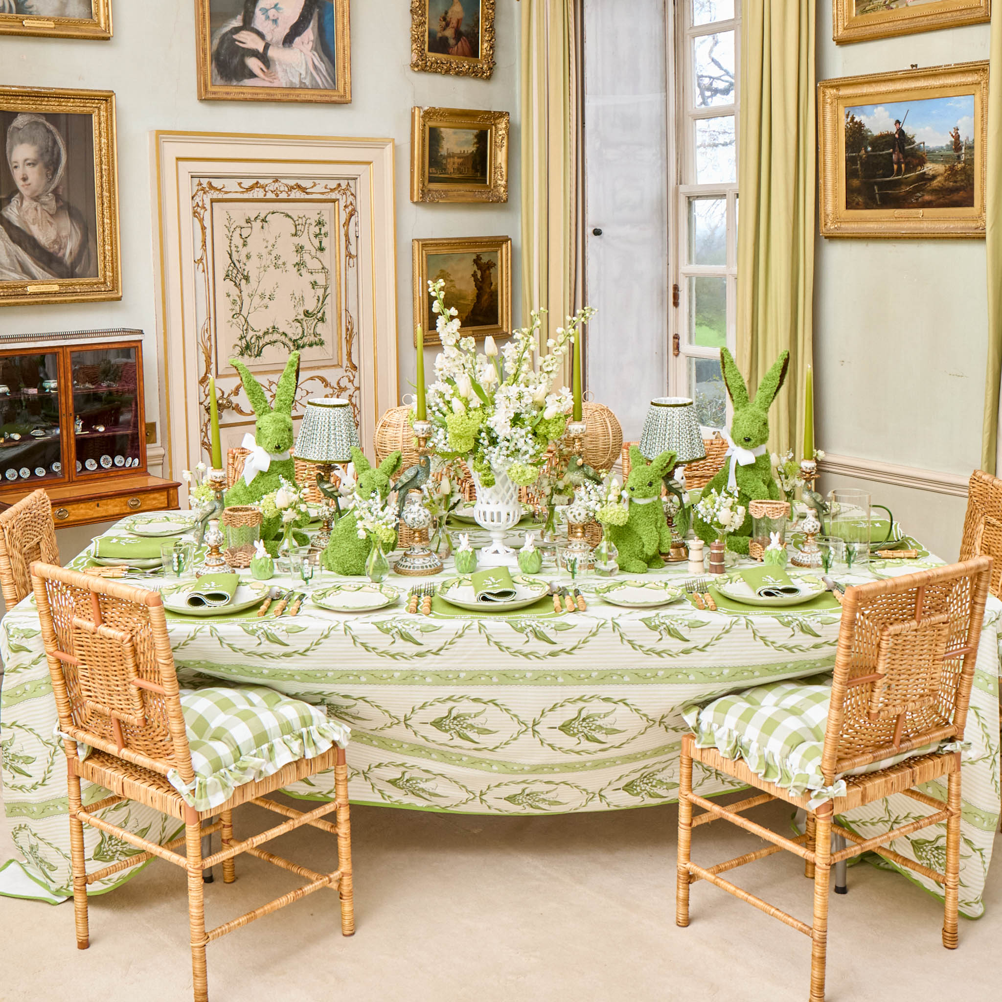 Dining room with a table set for a meal, featuring green and white decor.