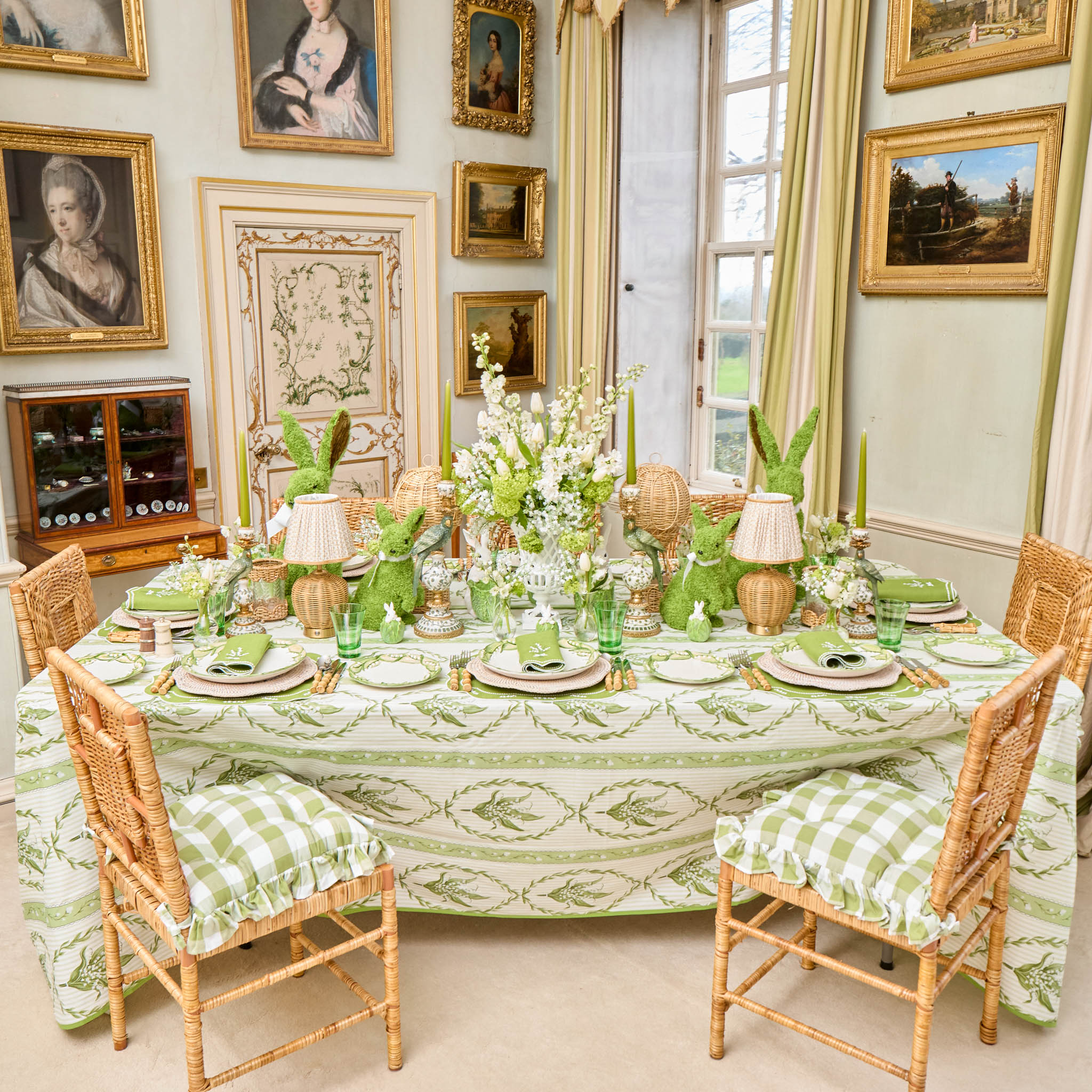 Elegant dining room with a table set for a meal, surrounded by framed pictures on the walls.