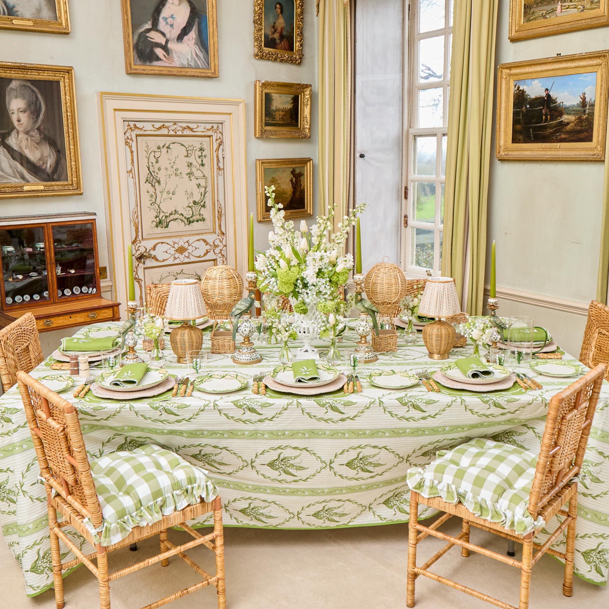 Elegant dining room with a table set for a meal, surrounded by framed artwork on the walls.