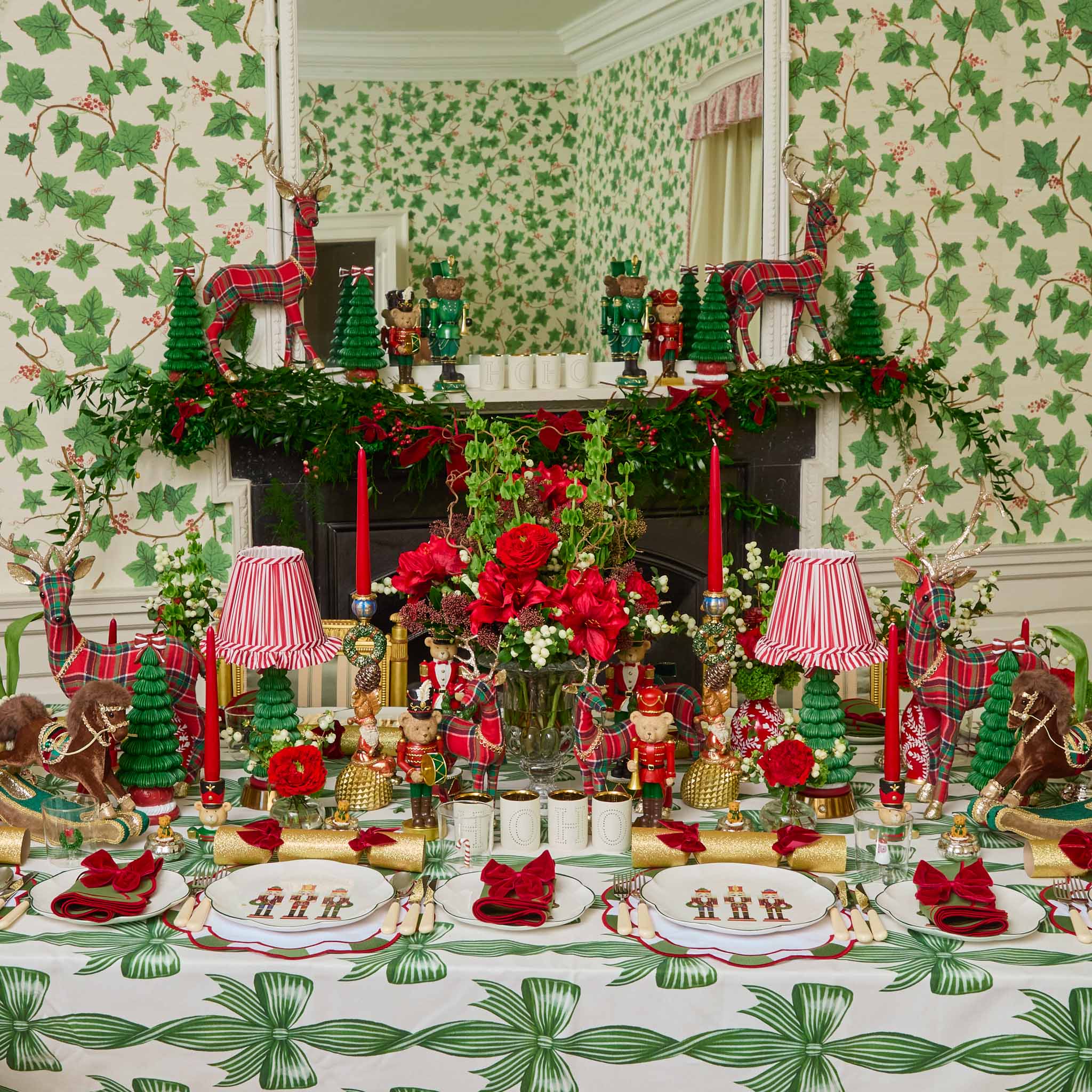 Decorative Christmas table setting with green and red theme, including reindeer and trees.
