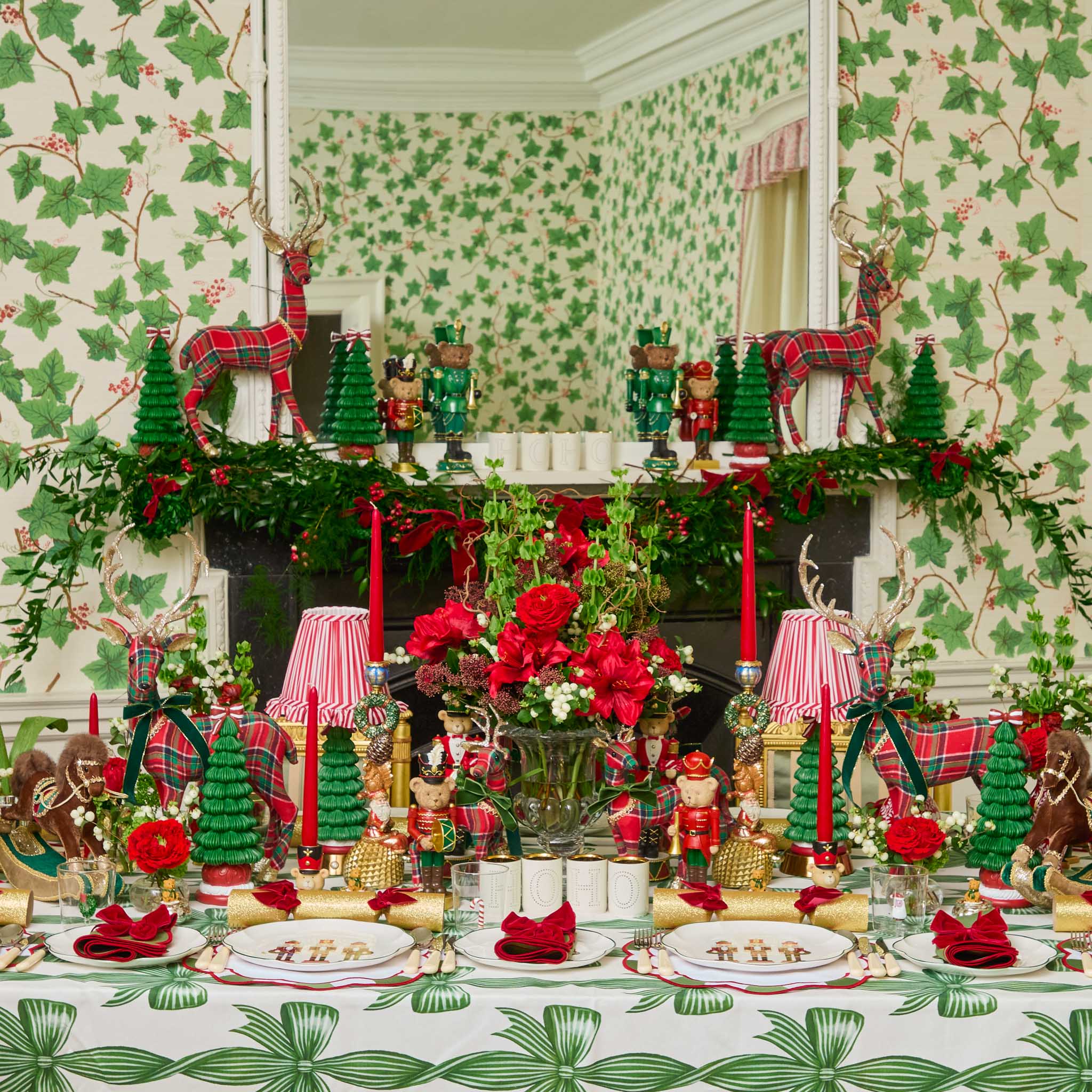 Decorative Christmas table setting with red and green theme in a room with patterned wallpaper.