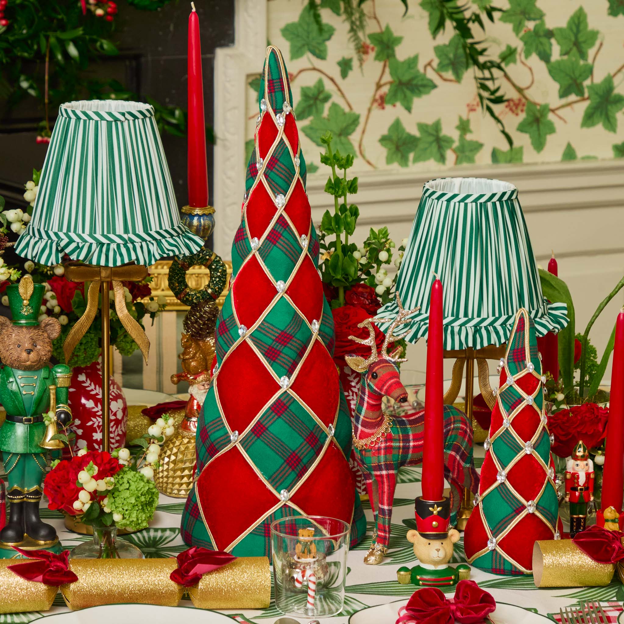 Decorative Christmas table setting with red and green plaid centerpieces, candles, and ornaments.