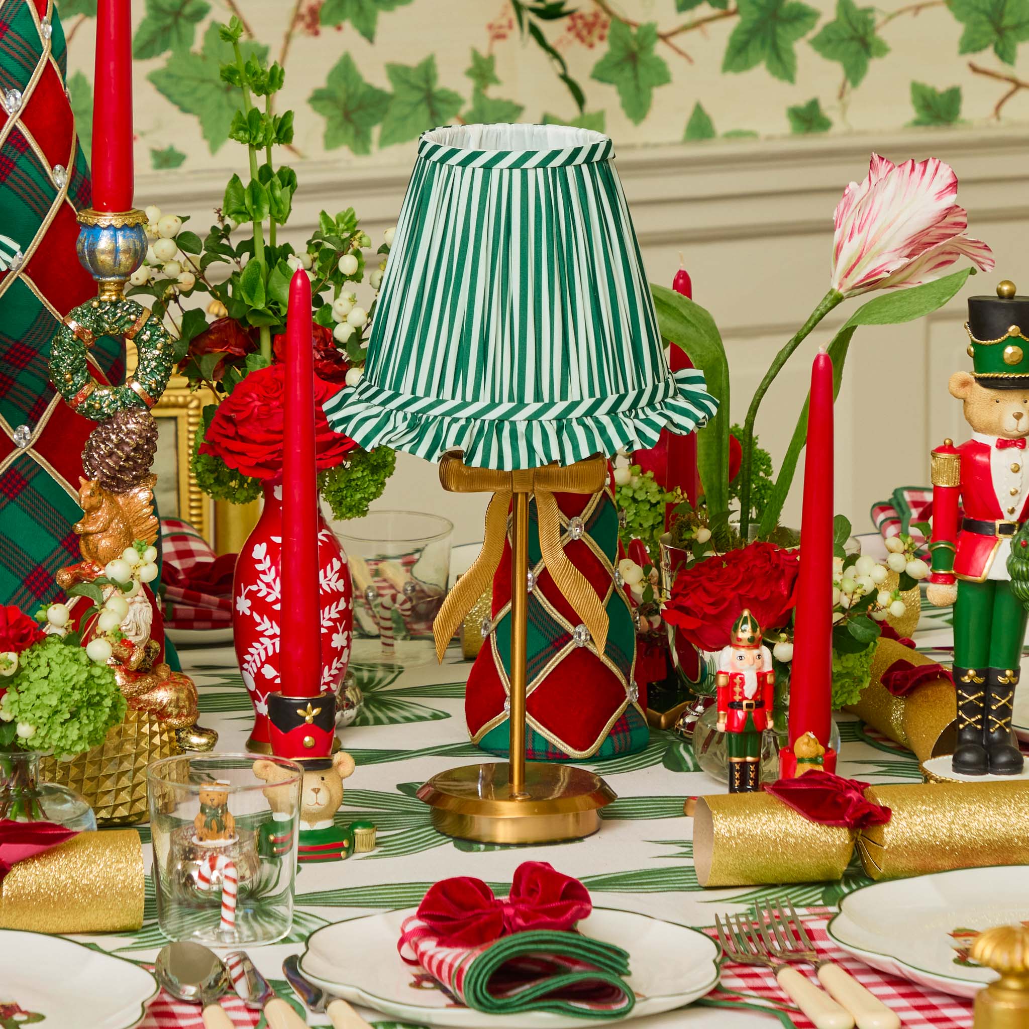 Decorative table setting with a lamp, candles, and festive decorations.
