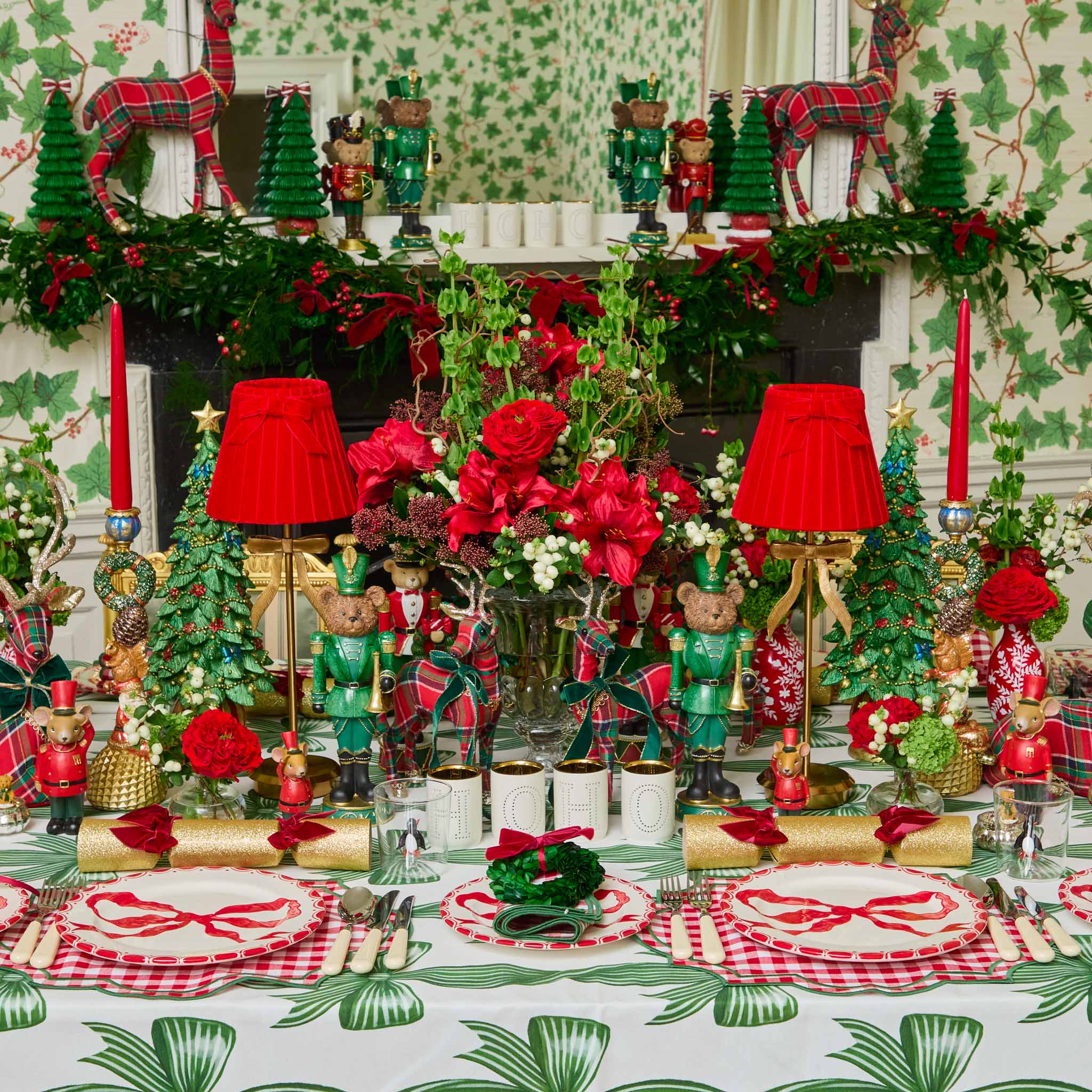 Decorative Christmas table setting with red and green theme, including tableware and centerpieces.
