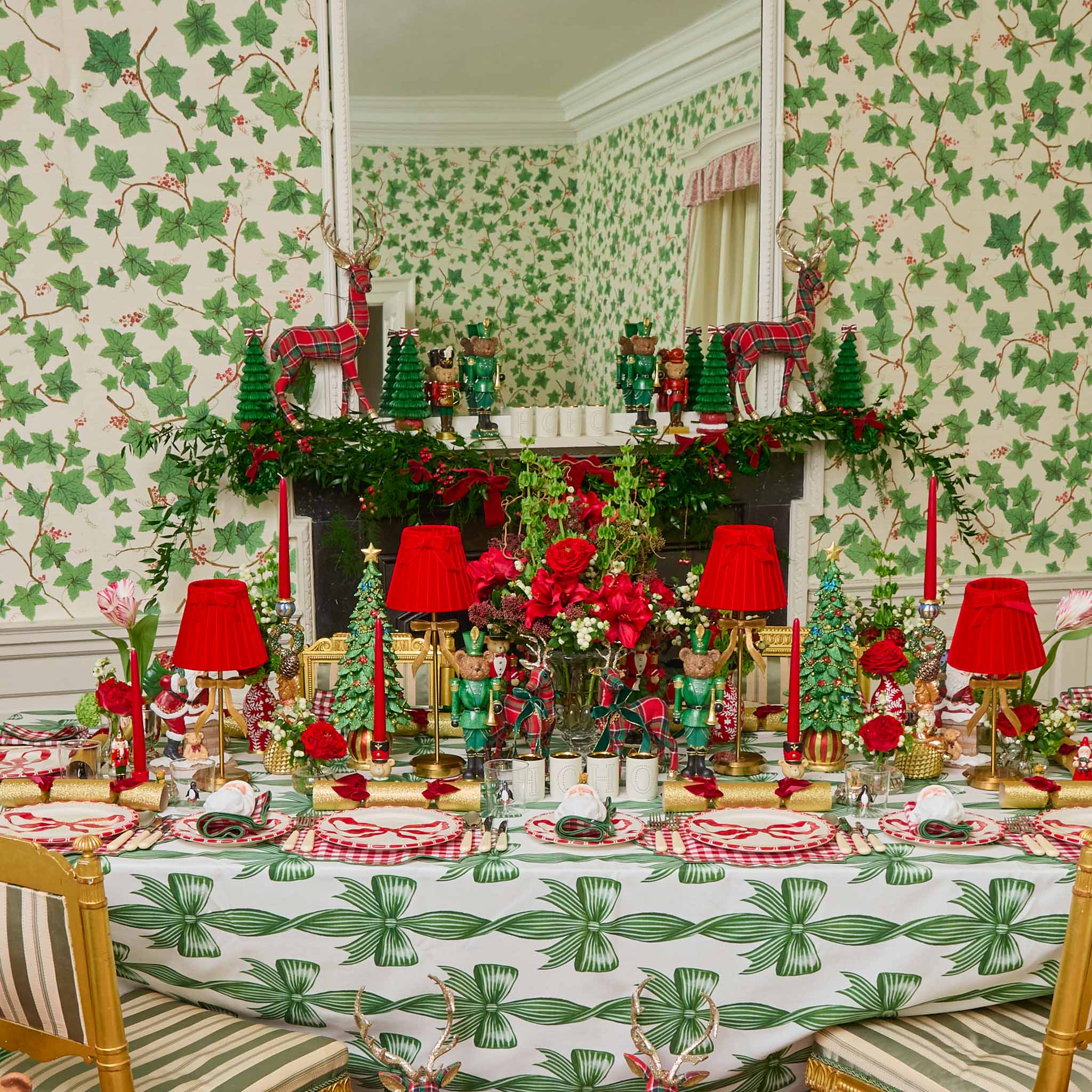 Decorative Christmas table setting with red and green theme in a room with festive wallpaper.