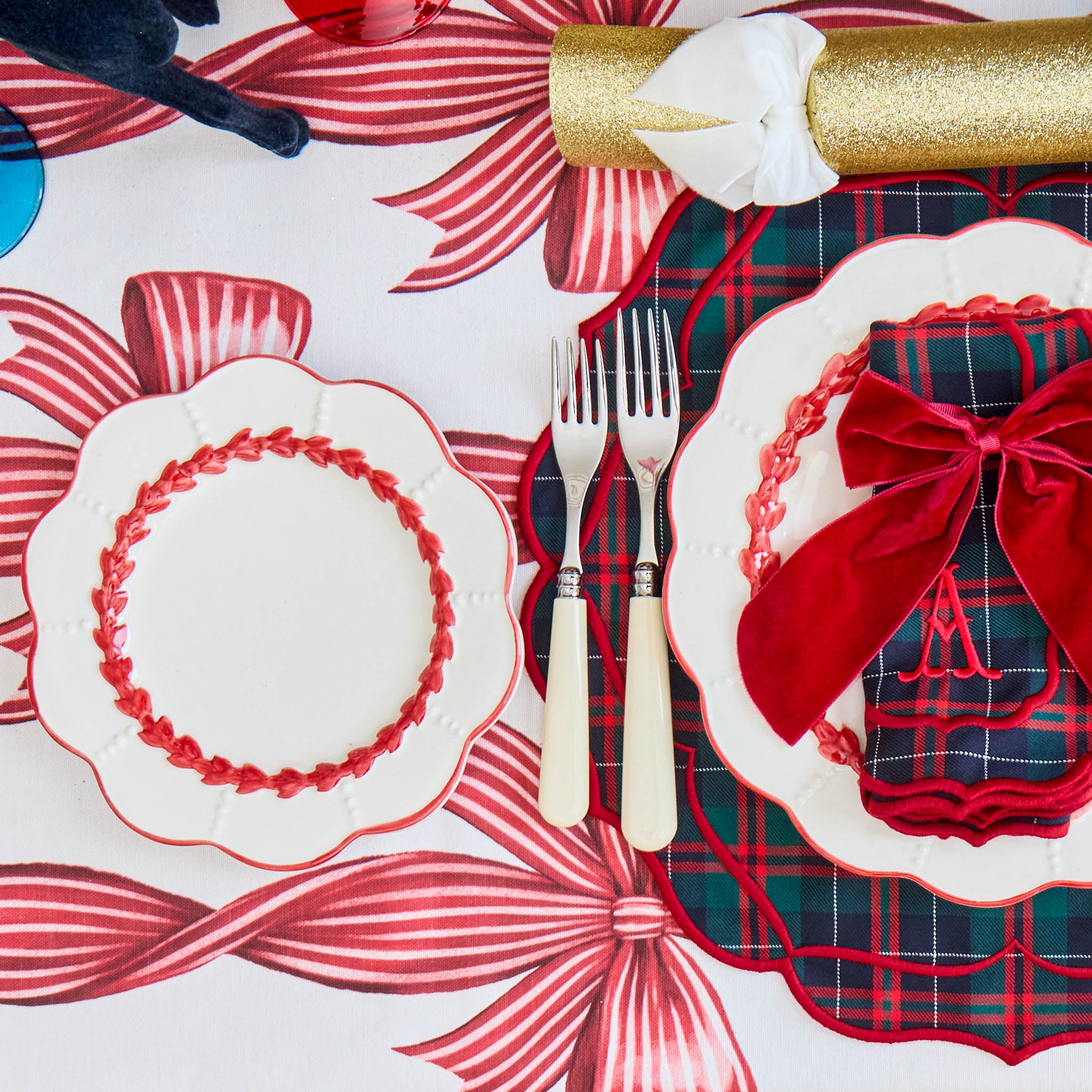 Decorative table setting with red and white plaid tablecloth, bow-shaped placemats, and cutlery.