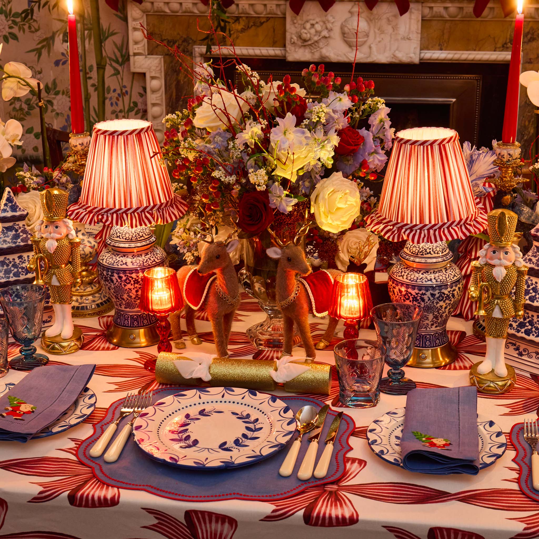 Decorative table setting with lamps, flowers, and nutcrackers in a festive room.