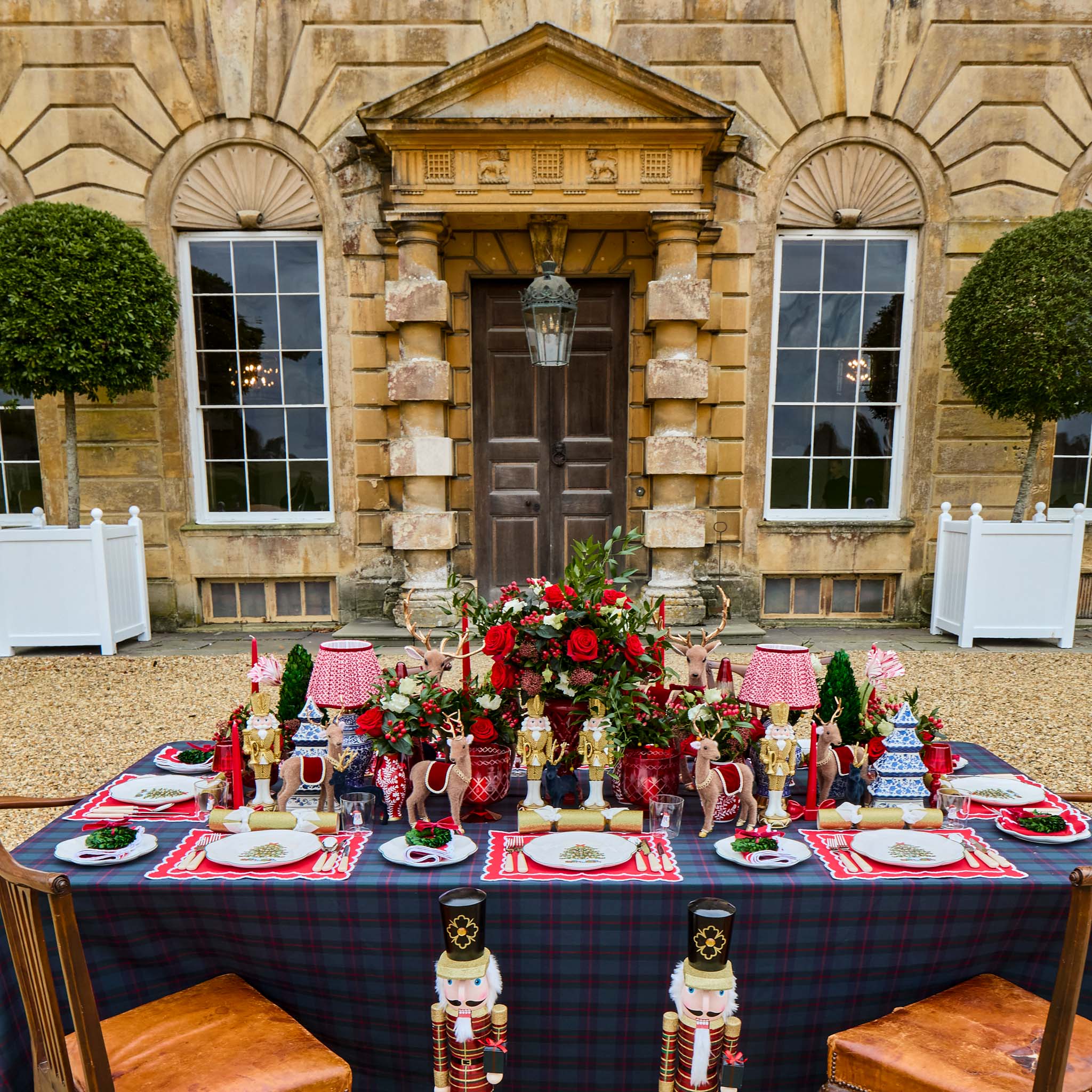 Decorative table setting with flowers and nutcrackers in front of a stone building
