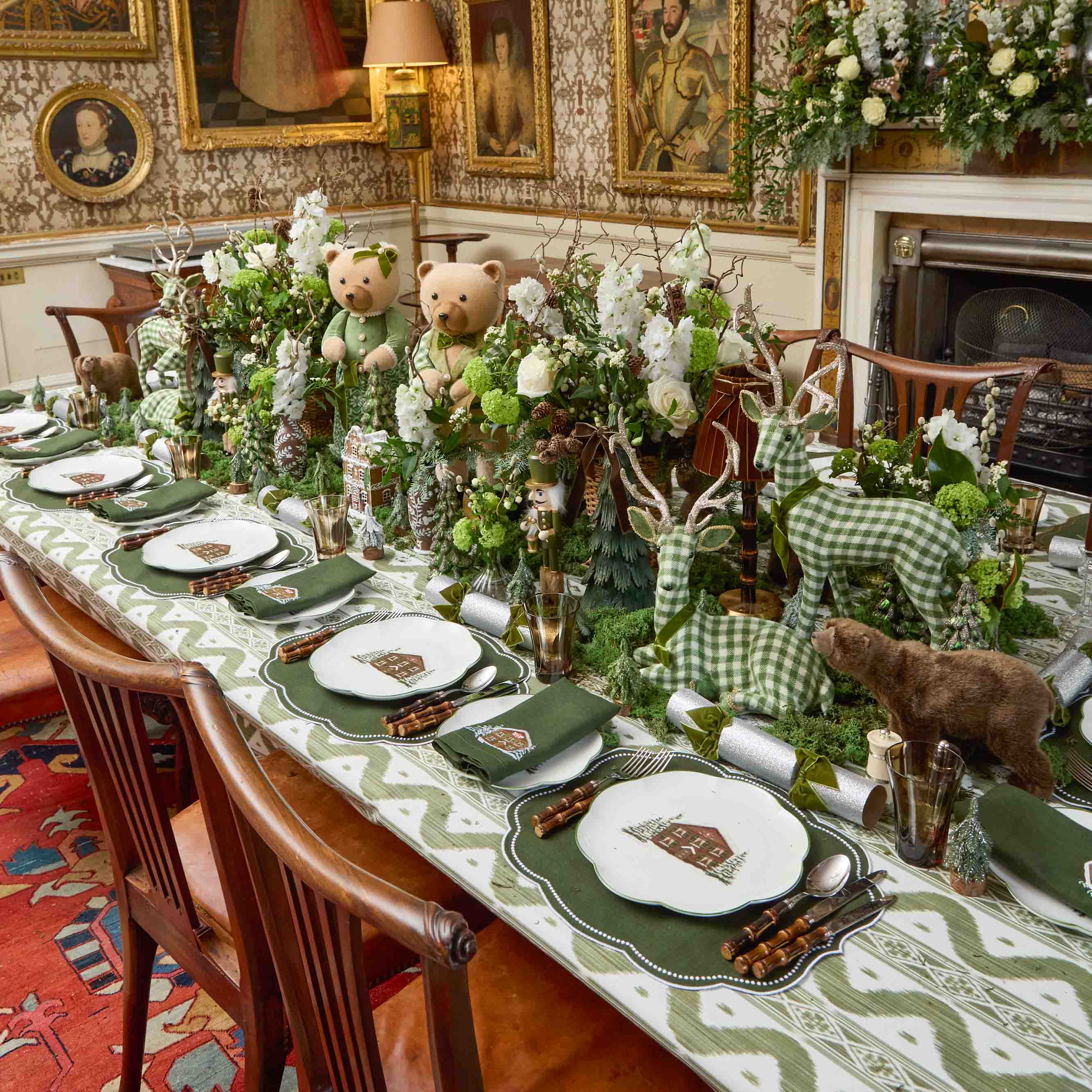 Decorative table setting with teddy bears, deer, and floral arrangements in a formal dining room.