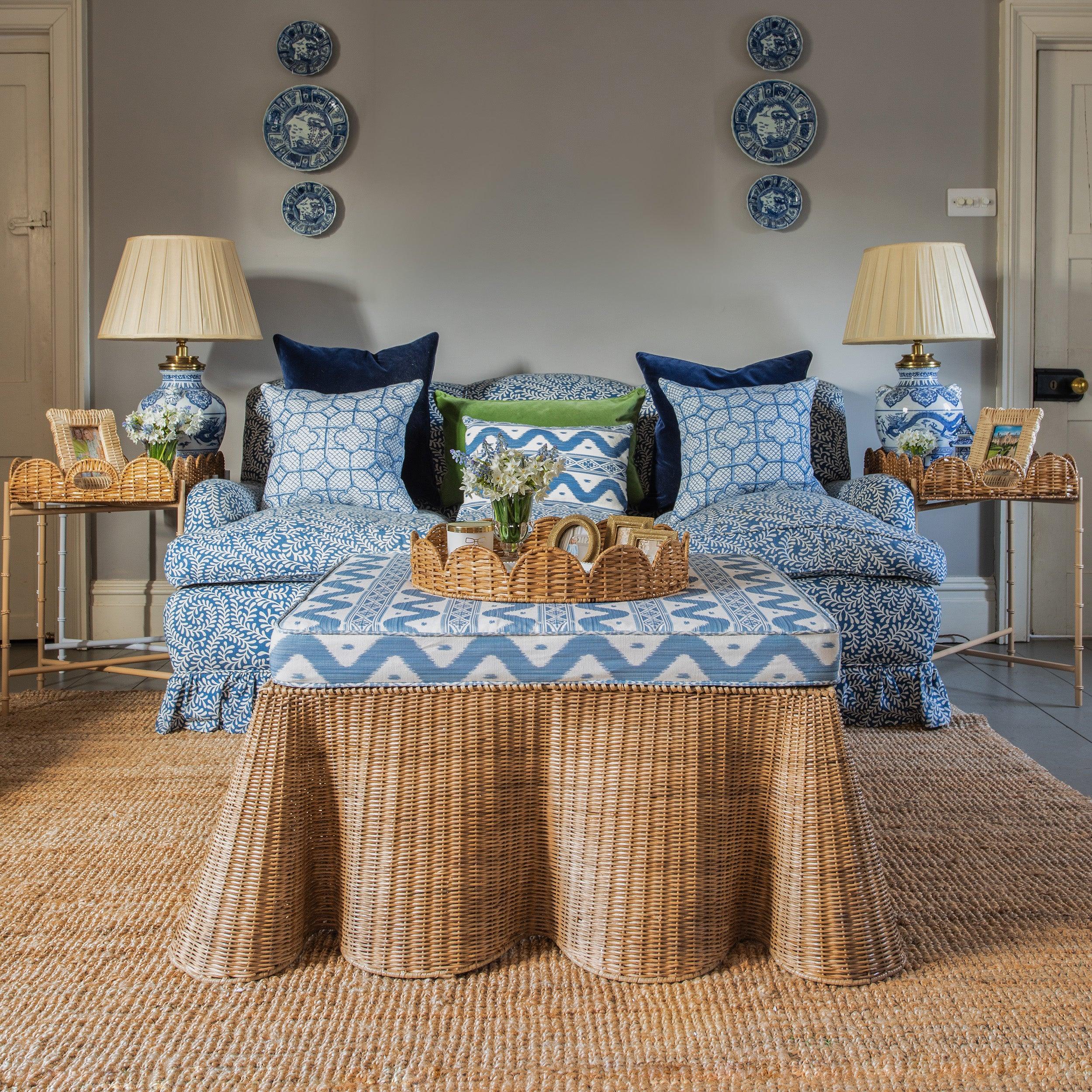 Enhance your living space with the playful and delightful Vivienne Rattan Scalloped Ottoman - a stylish choice that adds a dash of coastal elegance and an extra place to sit in your decor.