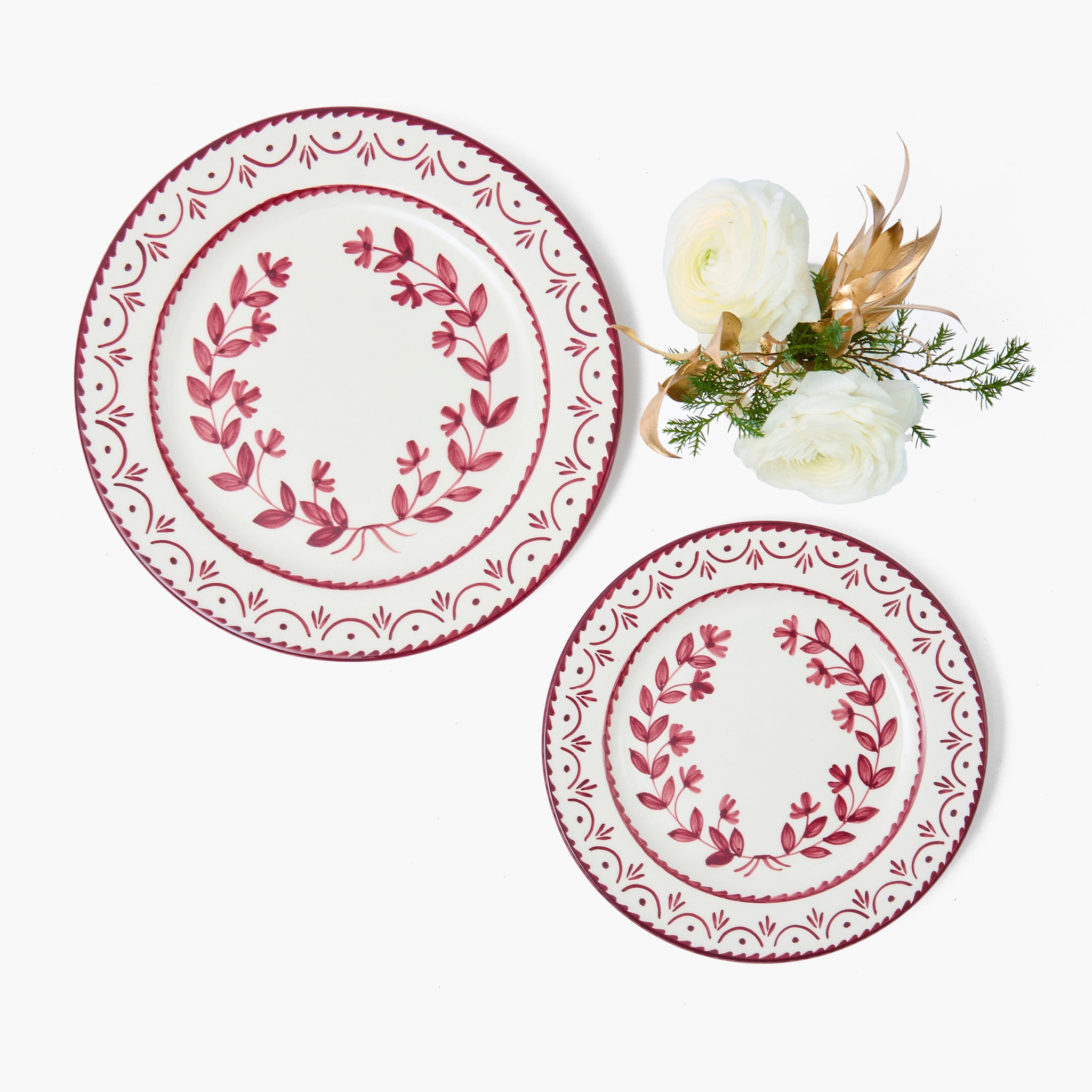 Two decorative plates with red floral patterns on a white background
