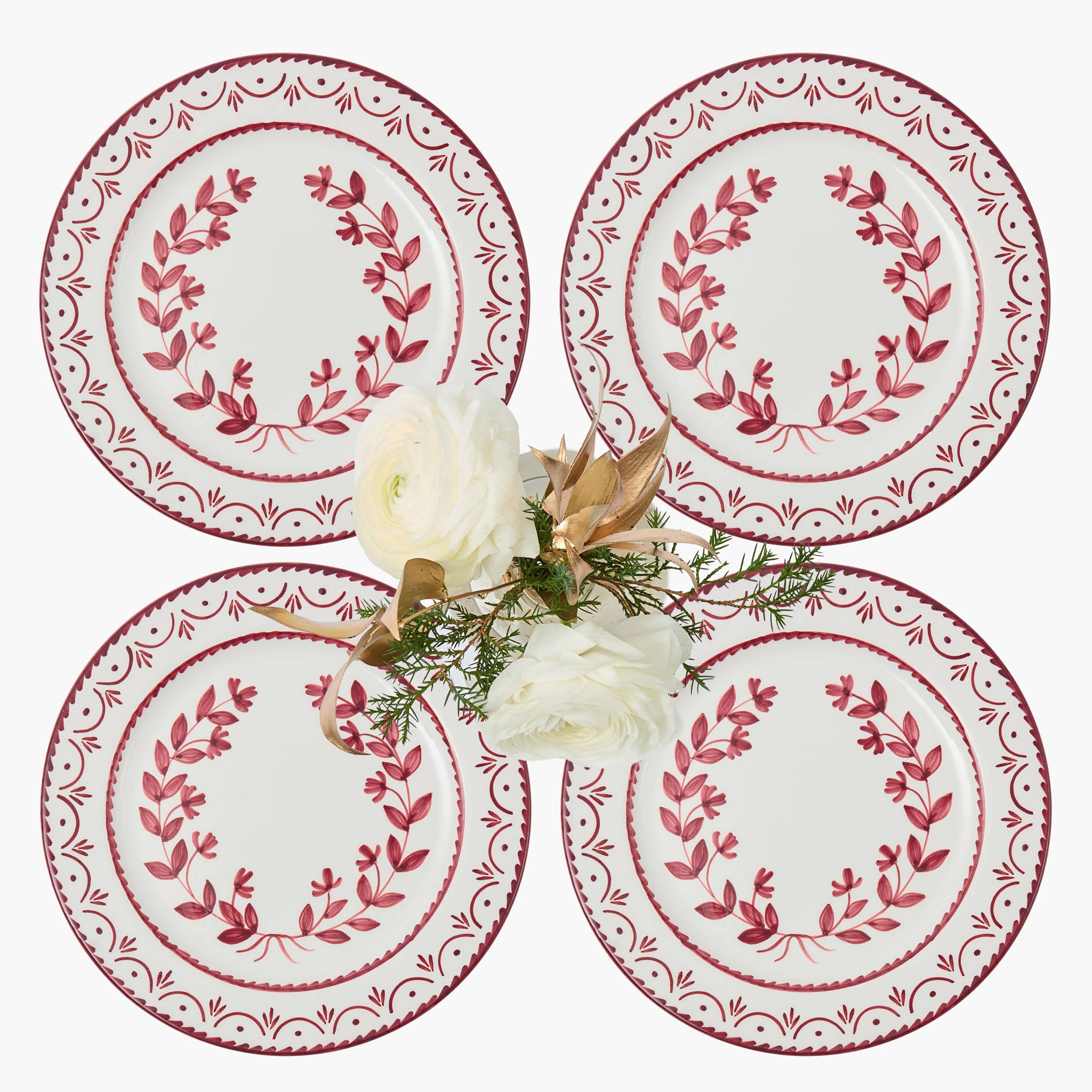 Four decorative plates with red floral patterns on a white background