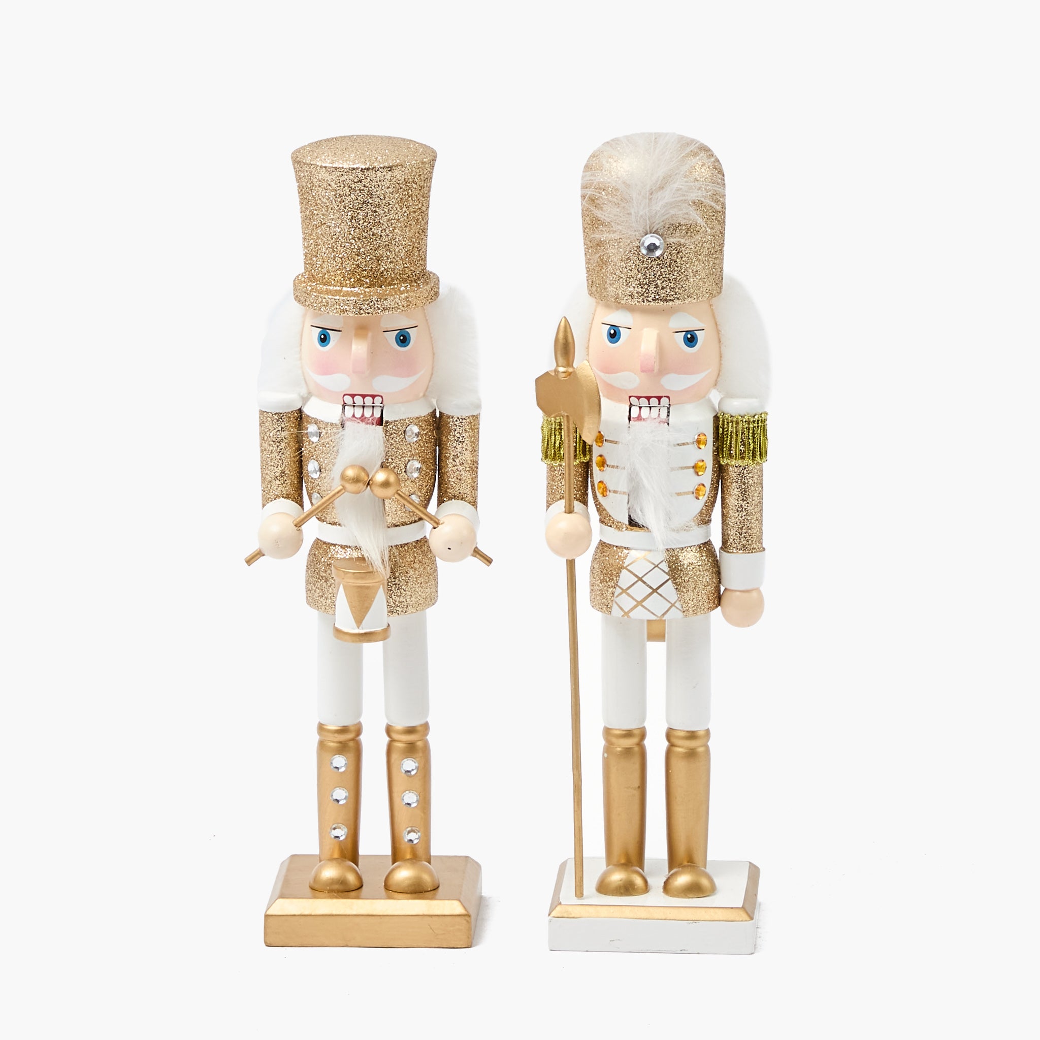 Two decorative nutcrackers in gold and white outfits on a white background
