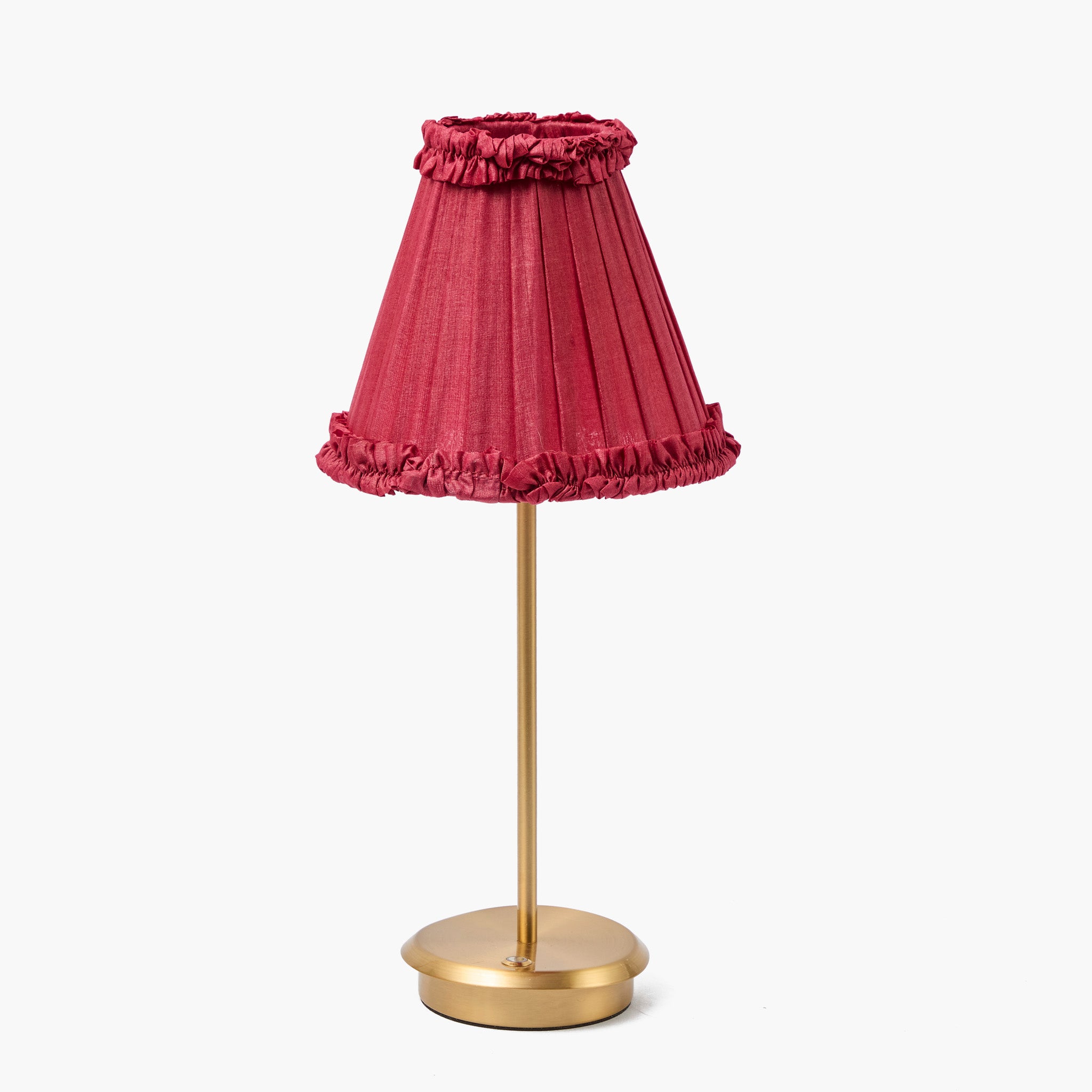 Table lamp with a pink pleated shade and gold base on a white background