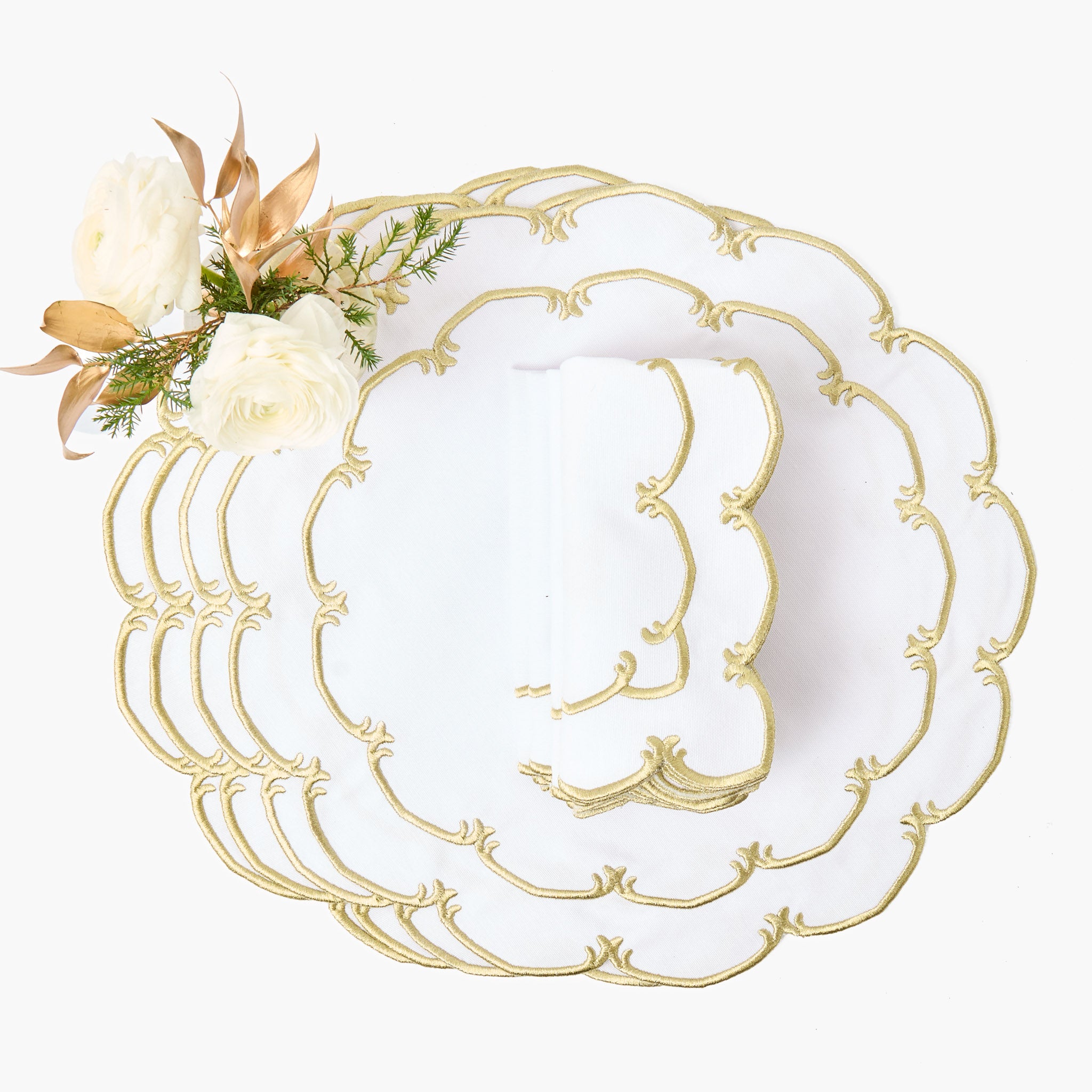Set of white plates with gold decorative edge on a white background