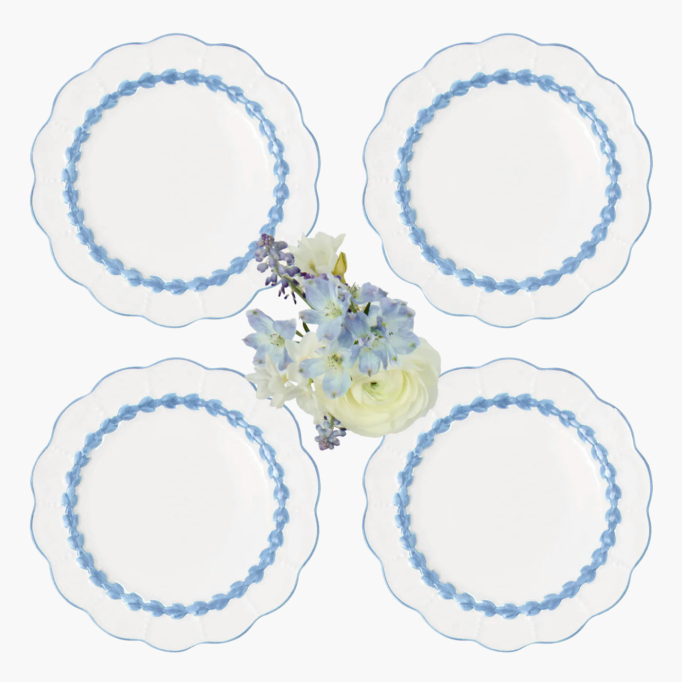 Set of four decorative plates with blue floral rim design on a white background.