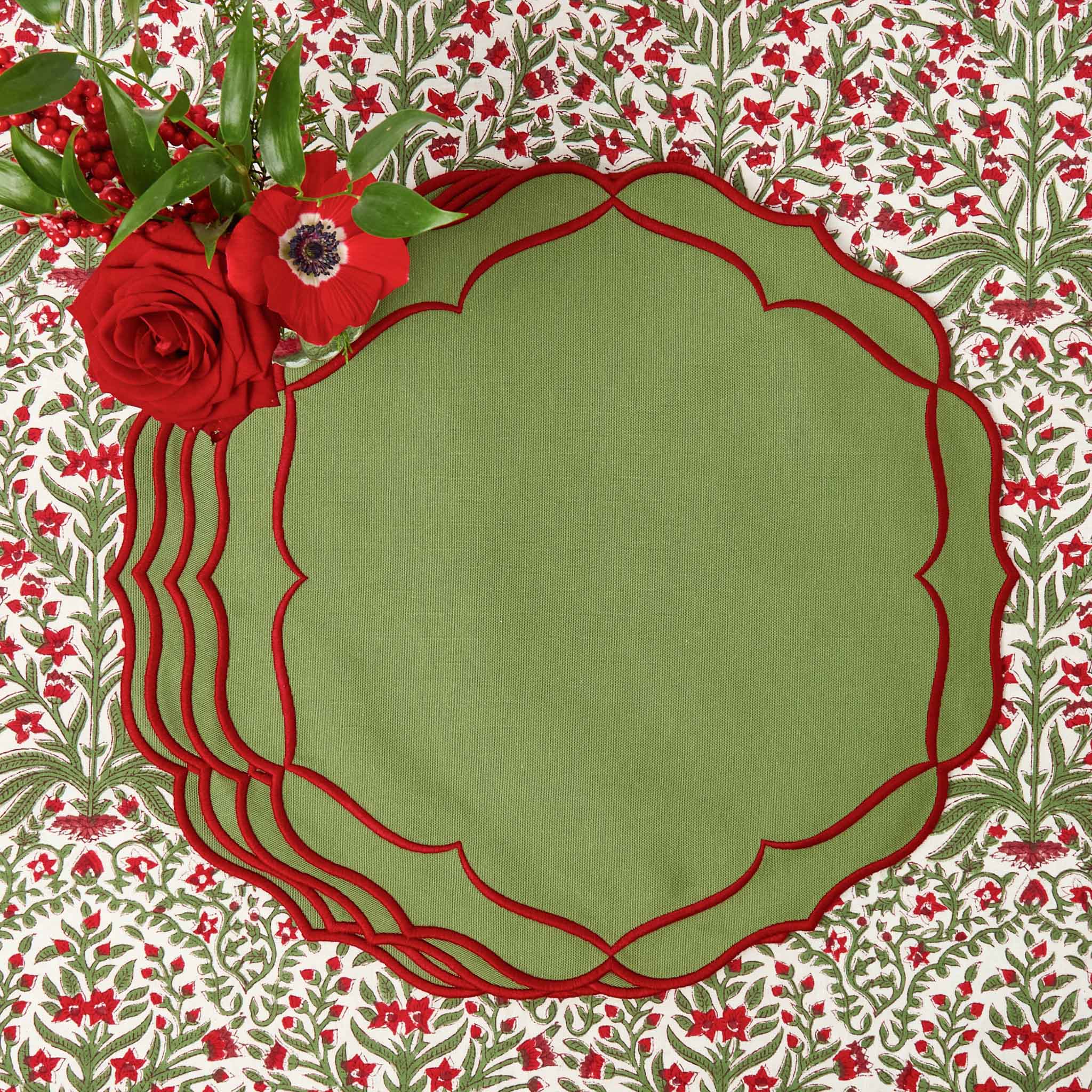 Green placemat with red decorative edge on a floral patterned background