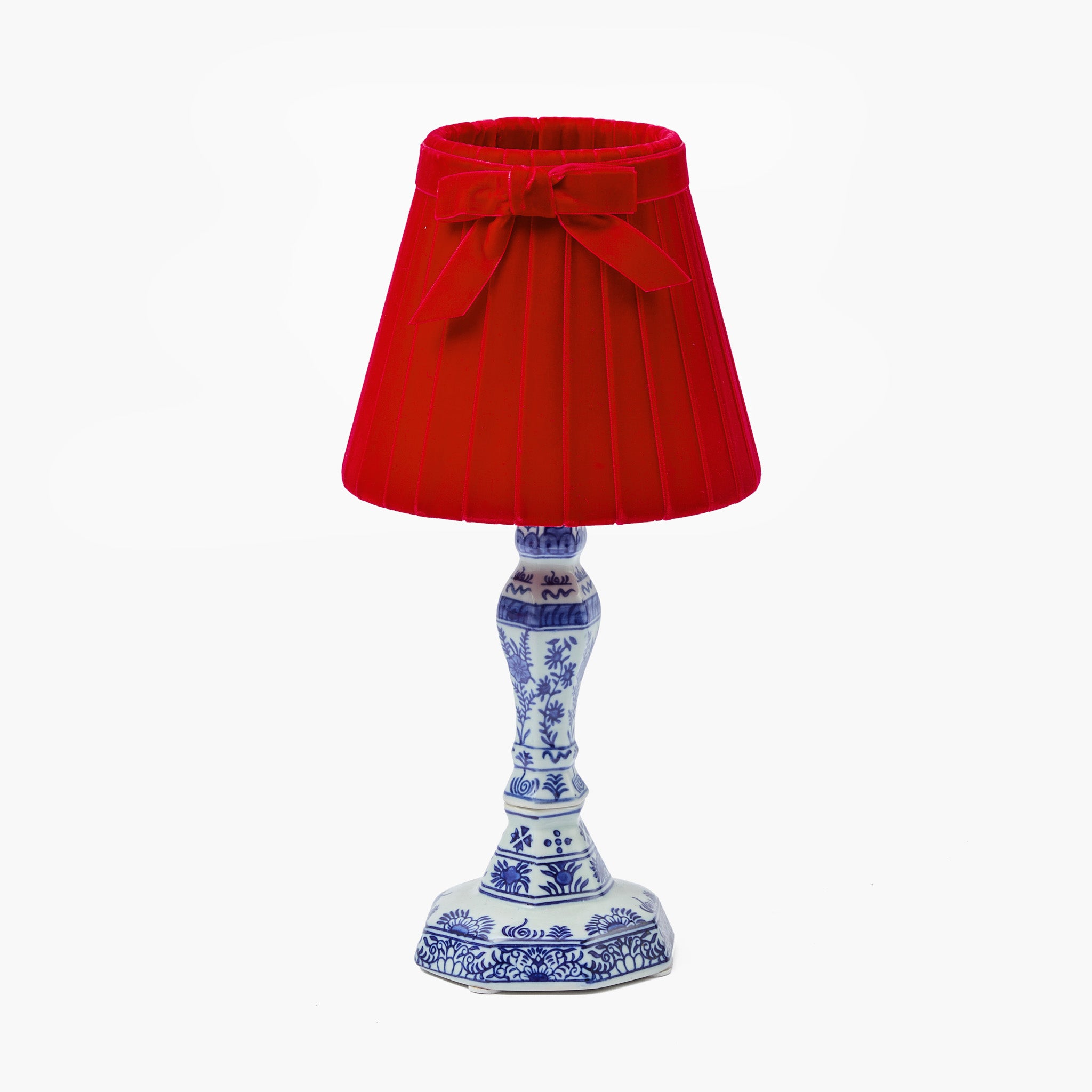 Decorative lamp with a red shade and blue and white base on a white background