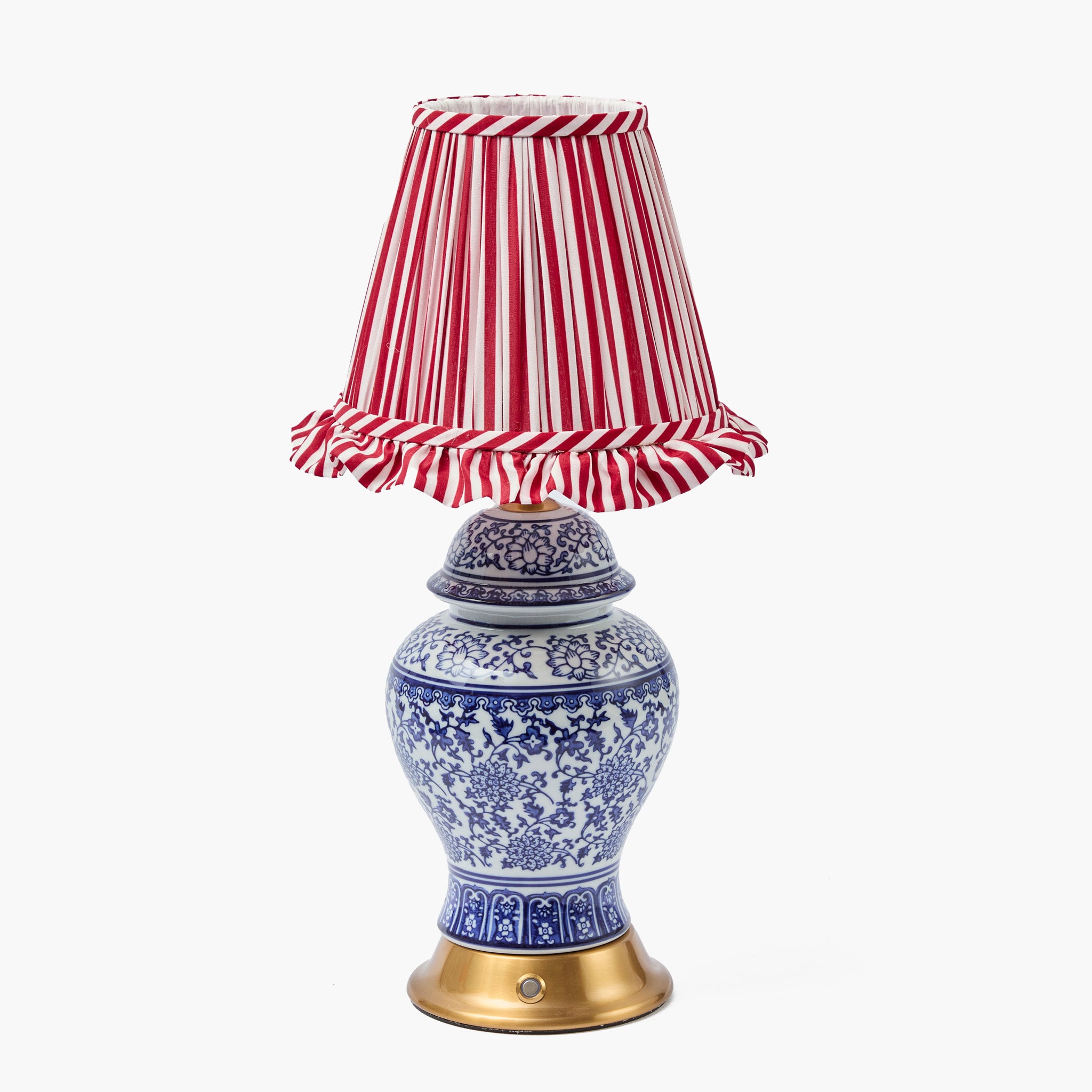 Decorative lamp with a blue and white patterned base and a red and white striped shade on a white background