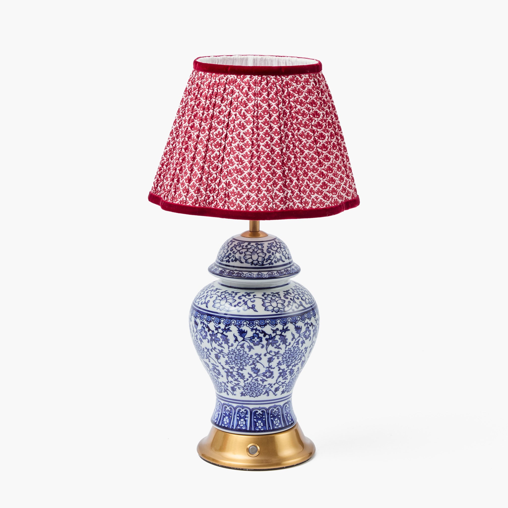 Decorative lamp with a red patterned shade on a white background
