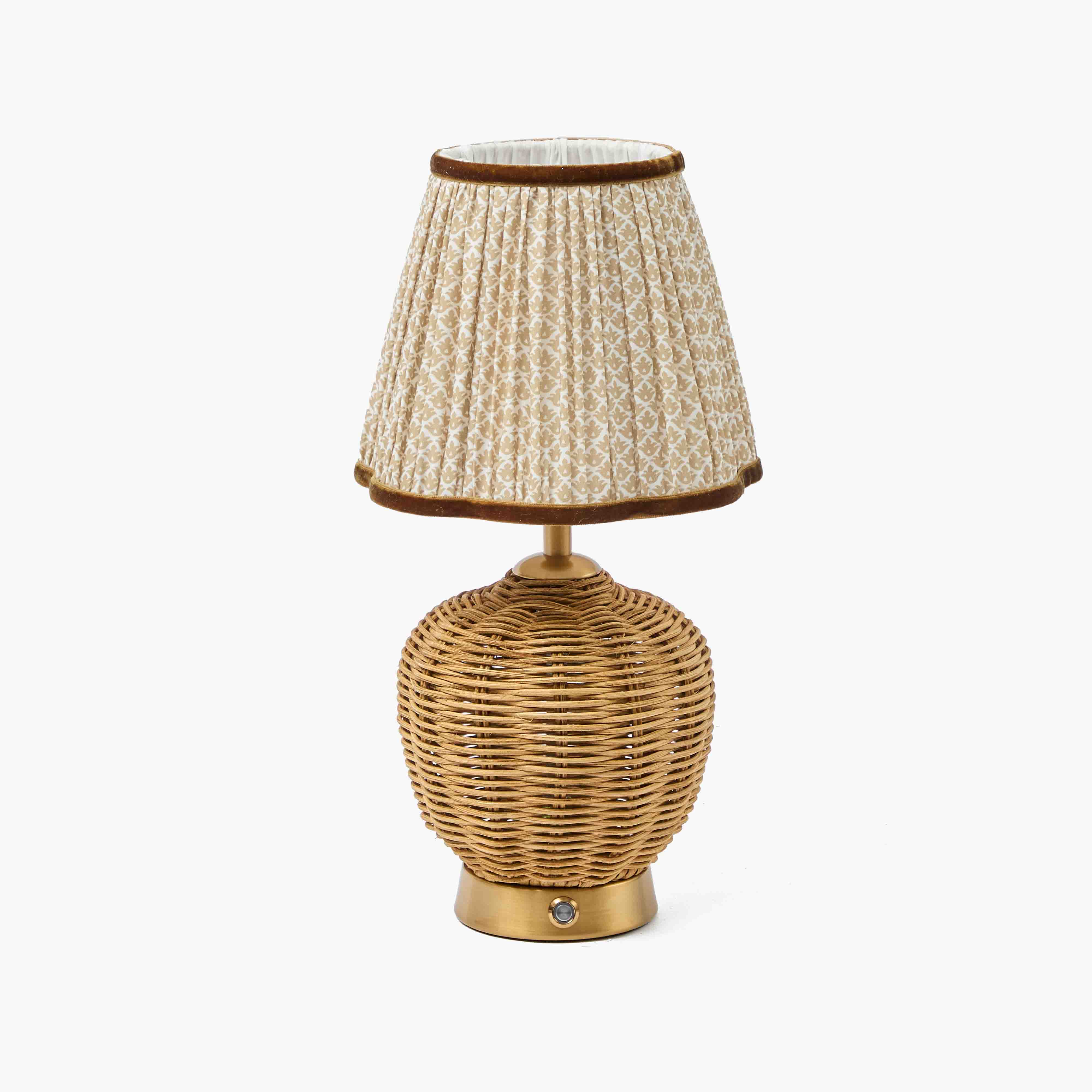 Table lamp with wicker base and textured fabric shade on a white background