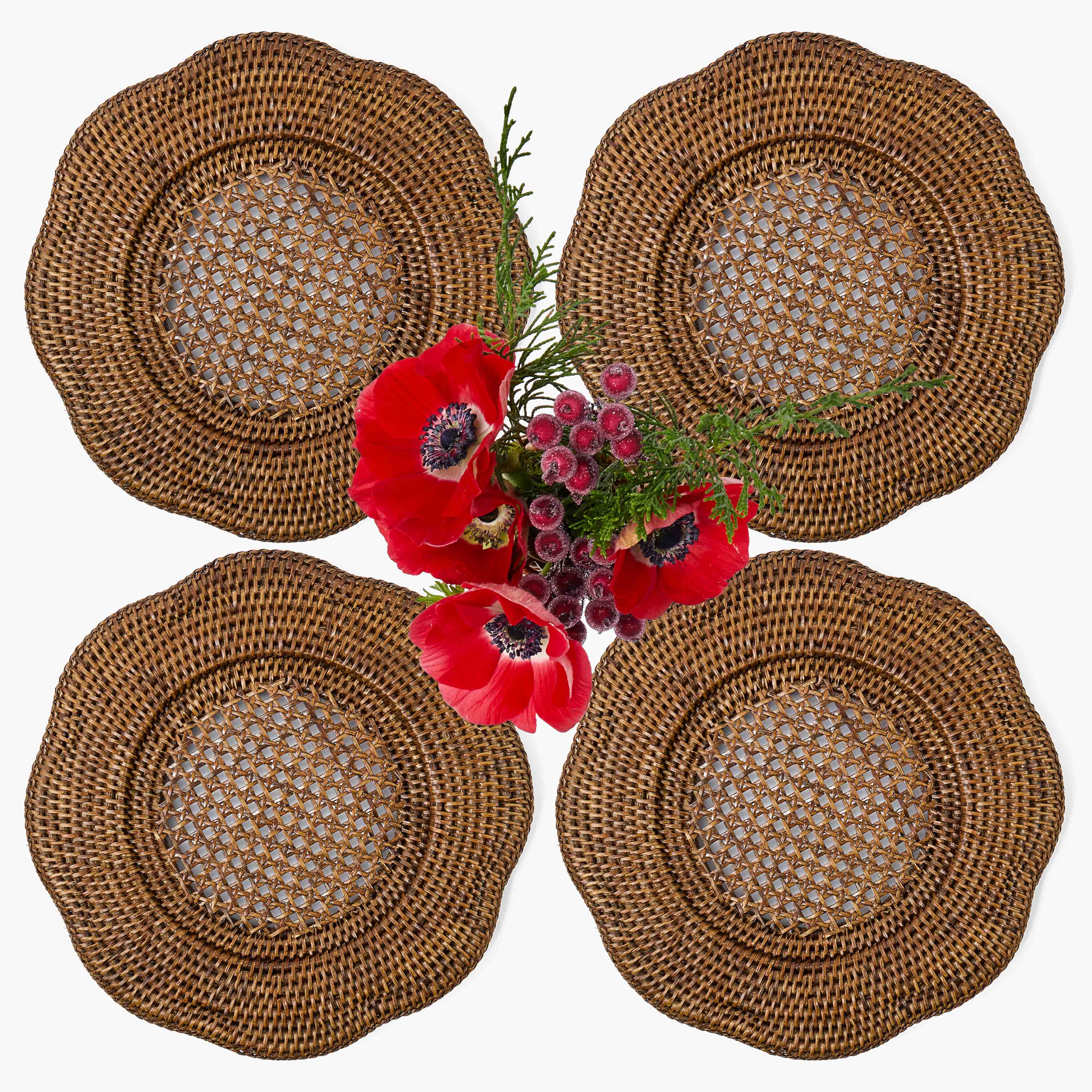 Four woven placemats with a bouquet of red and pink flowers in the center on a white background.