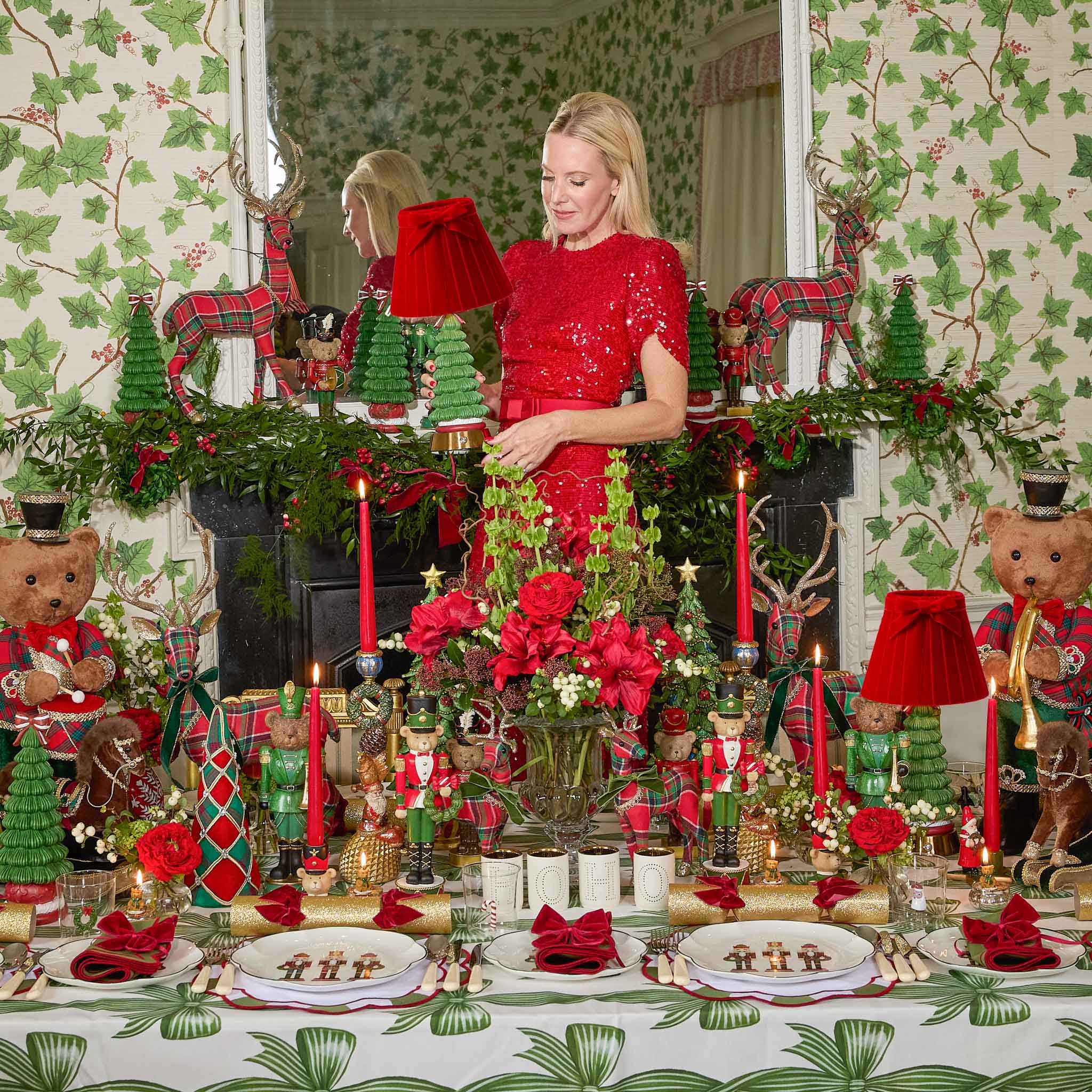 Woman in a red dress standing in a festively decorated room with Christmas decorations.