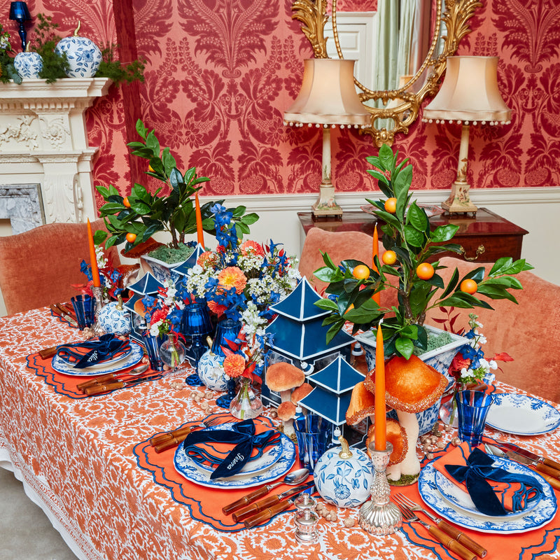 Burnt orange tablecloth with intricate illustrations of pheasants.