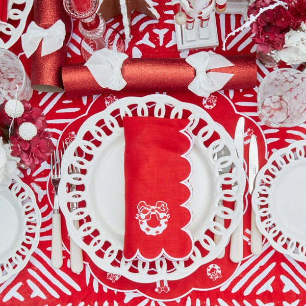 Create an enchanting holiday table with this set of 4 red linen placemats and matching napkins, featuring intricate festive embroidery.