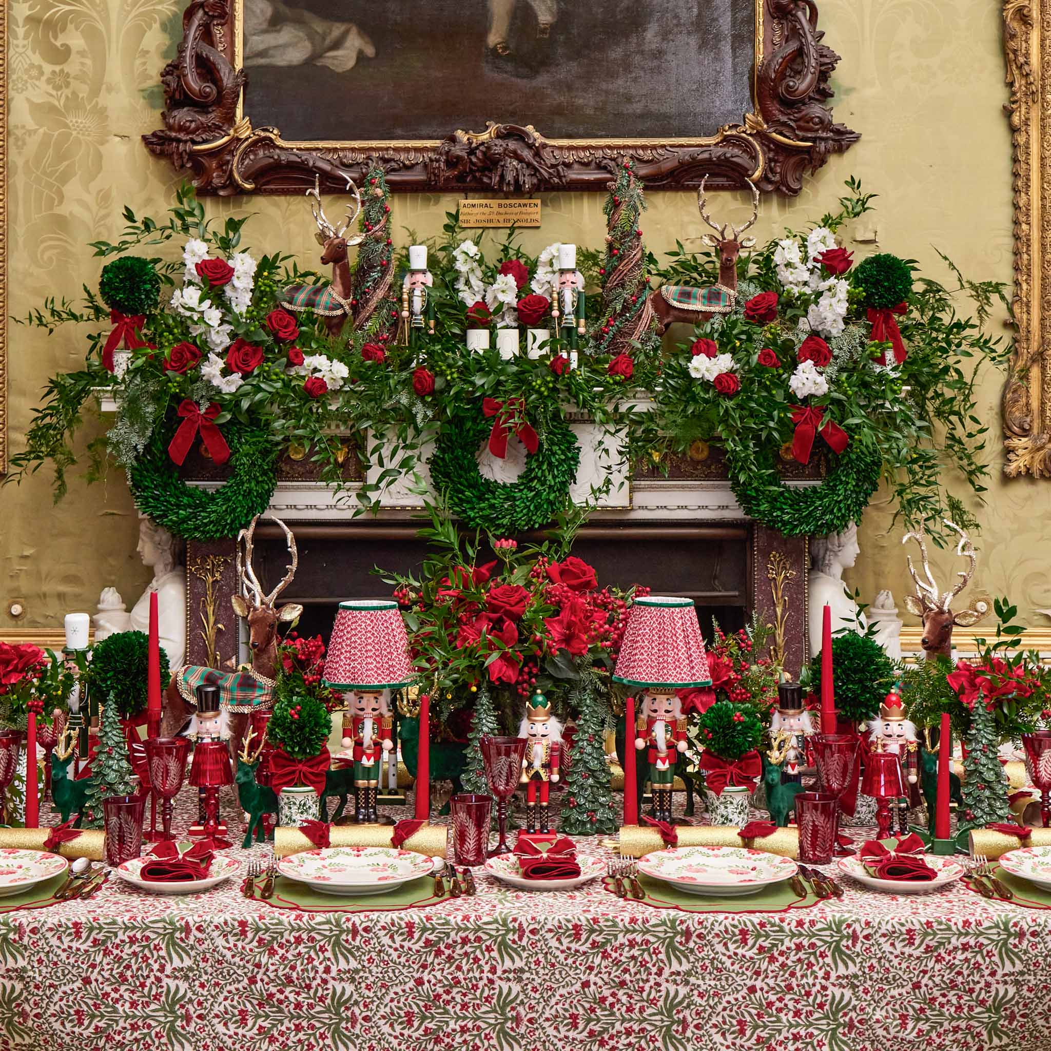 Decorative Christmas table setting with red and green theme in a room with ornate decorations.