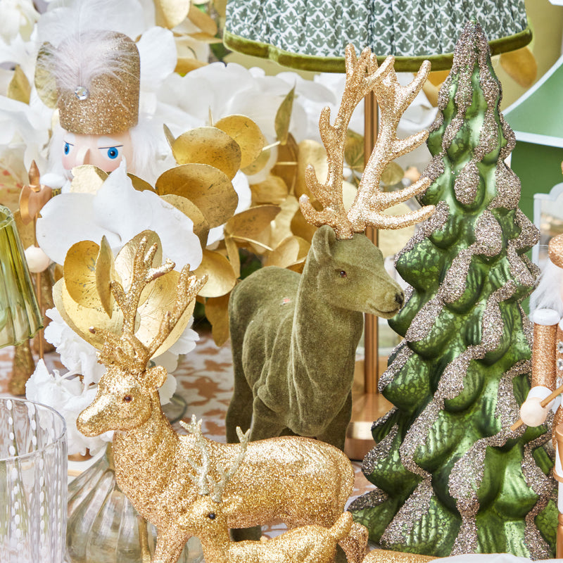Add a touch of rustic elegance to your holiday celebrations with the Olive Green Flocked Reindeer Family, perfect for creating a coordinated and warm atmosphere reminiscent of a forest holiday.