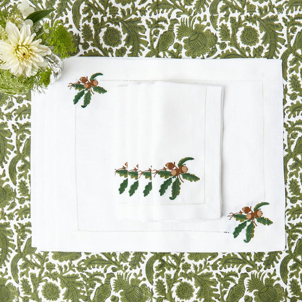 Set of 4 placemats adorned with charming acorn motifs on white linen.