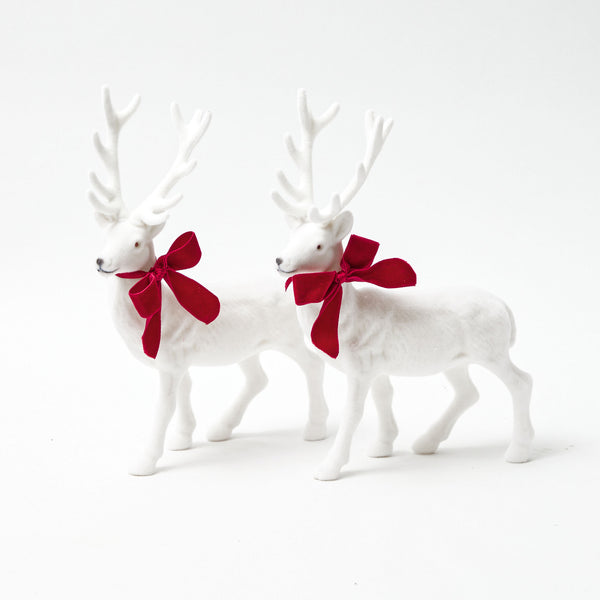 Elevate your holiday decor with the Large White Flocked Reindeer Pair, a graceful duo adorned with plush velvet bows that exude elegance.