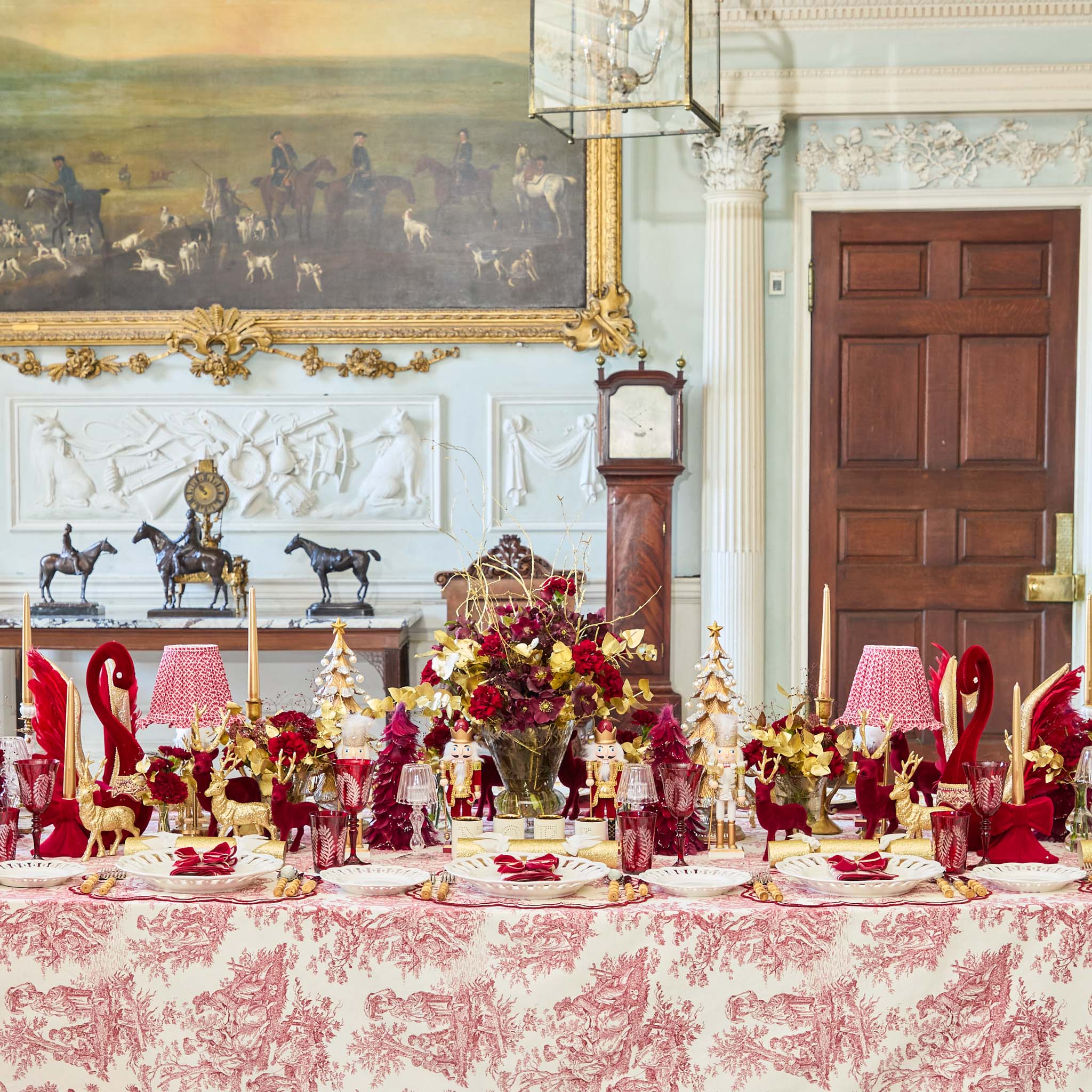 Decorative table setting with red and gold elements in a formal room.