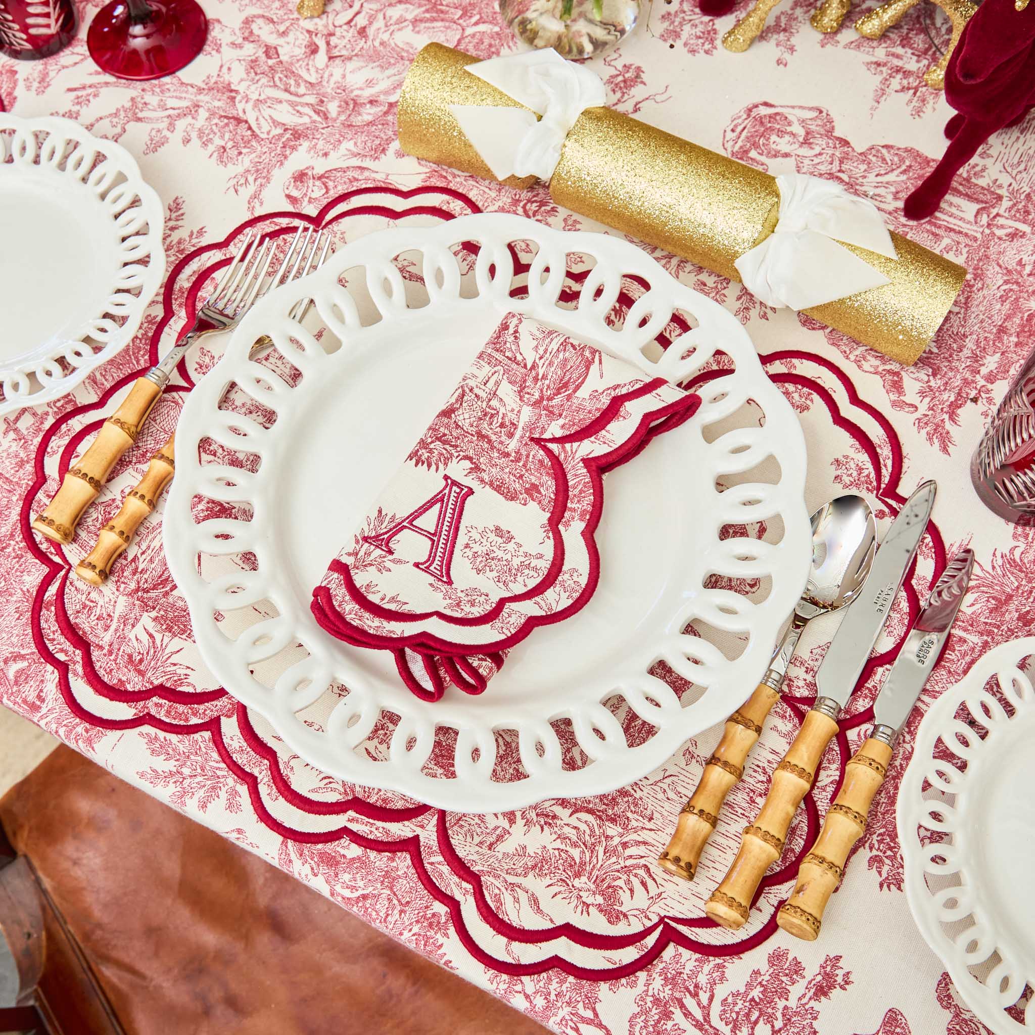 Decorative table setting with red and white patterned plates and placemats.