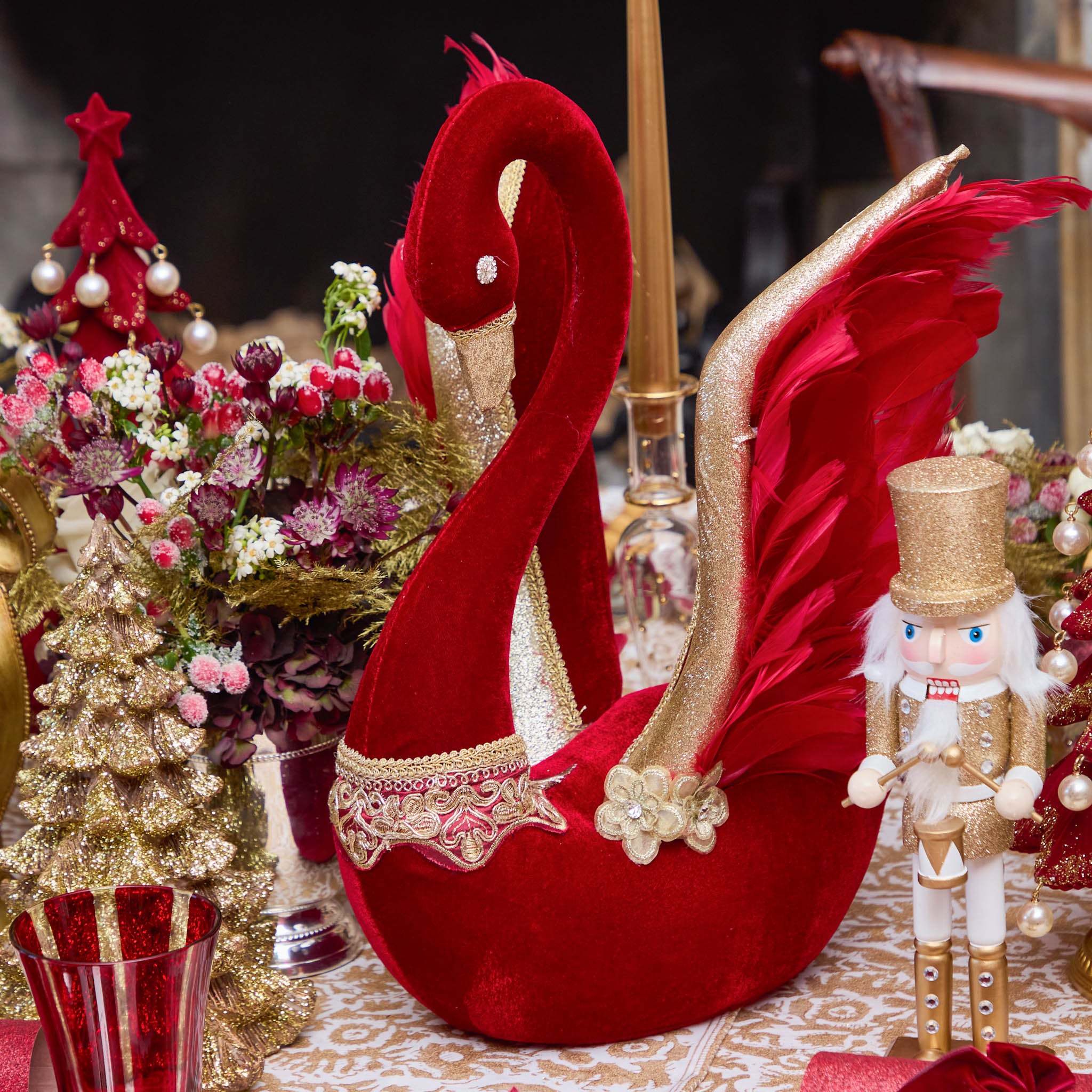 Decorative red swan with gold accents on a festive table setting.