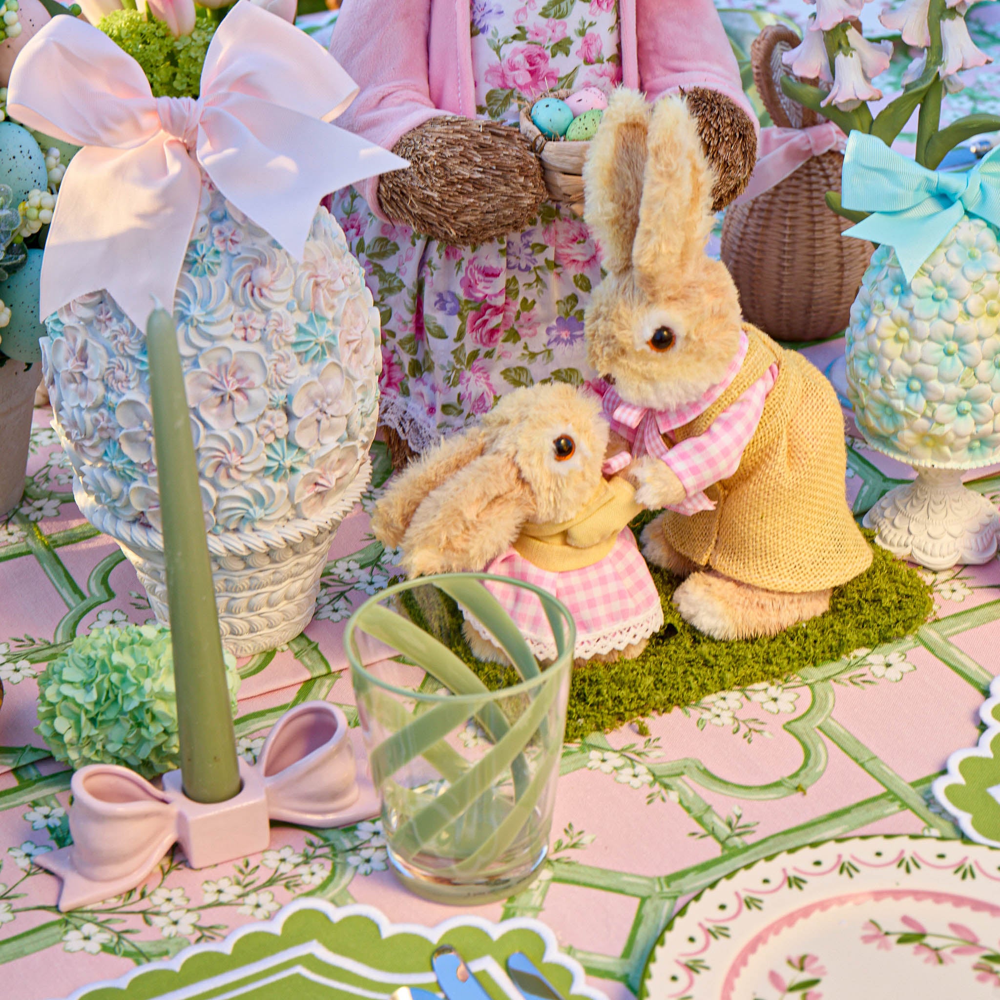 Decorative Easter scene with bunnies, eggs, and a pink floral dress.