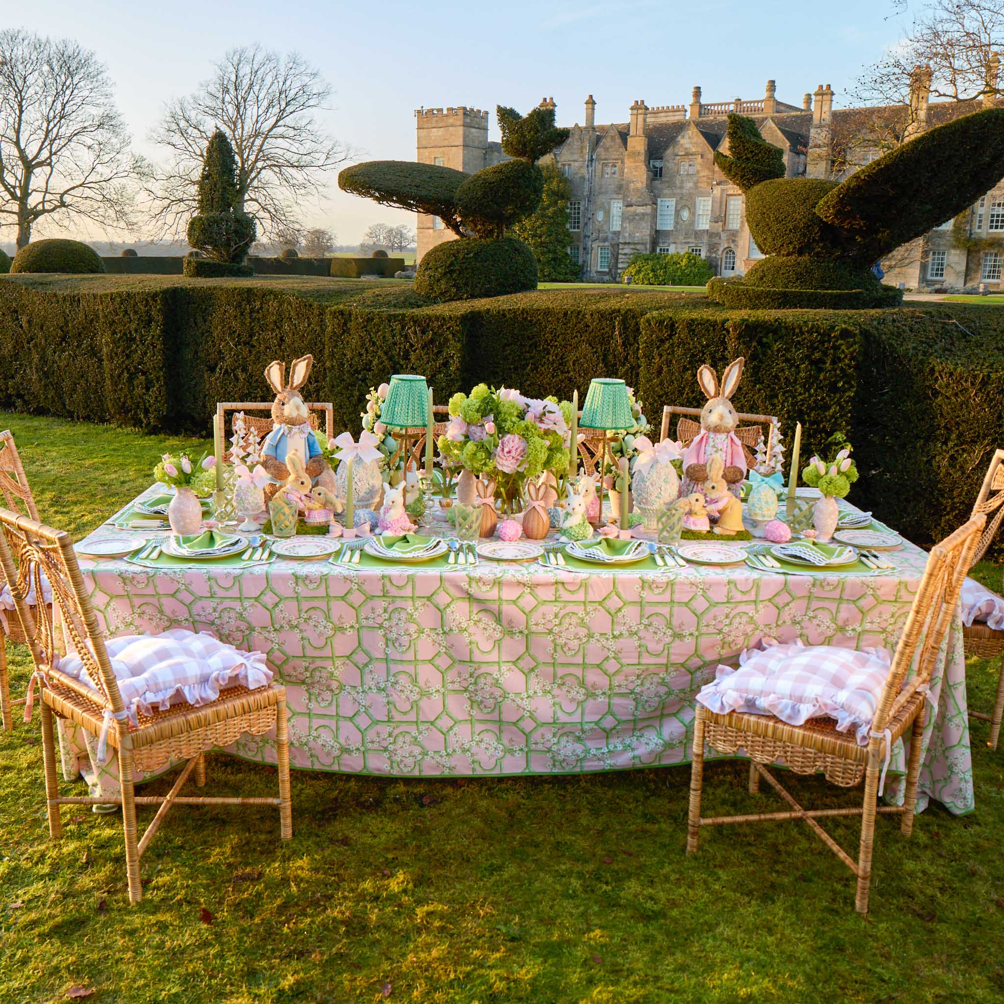Easter-themed table setting with bunny decorations in a garden.