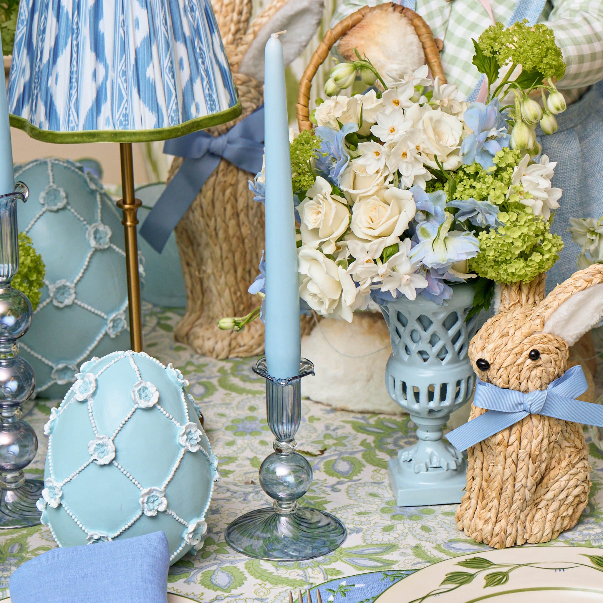 Decorative Easter table setting with bunny, eggs, and flowers.