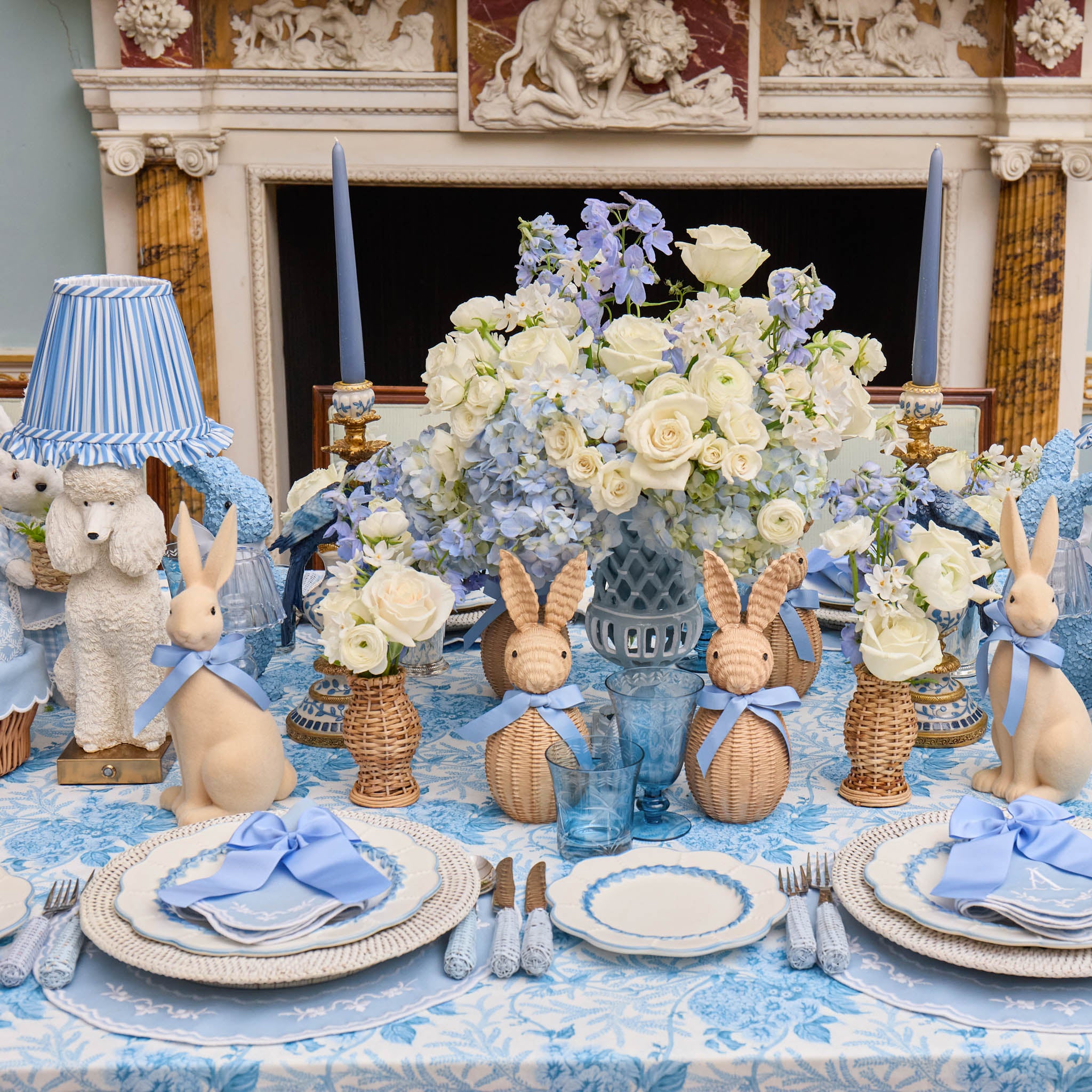 Easter-themed table setting with decorative elements including rabbits, flowers, and blue accents.